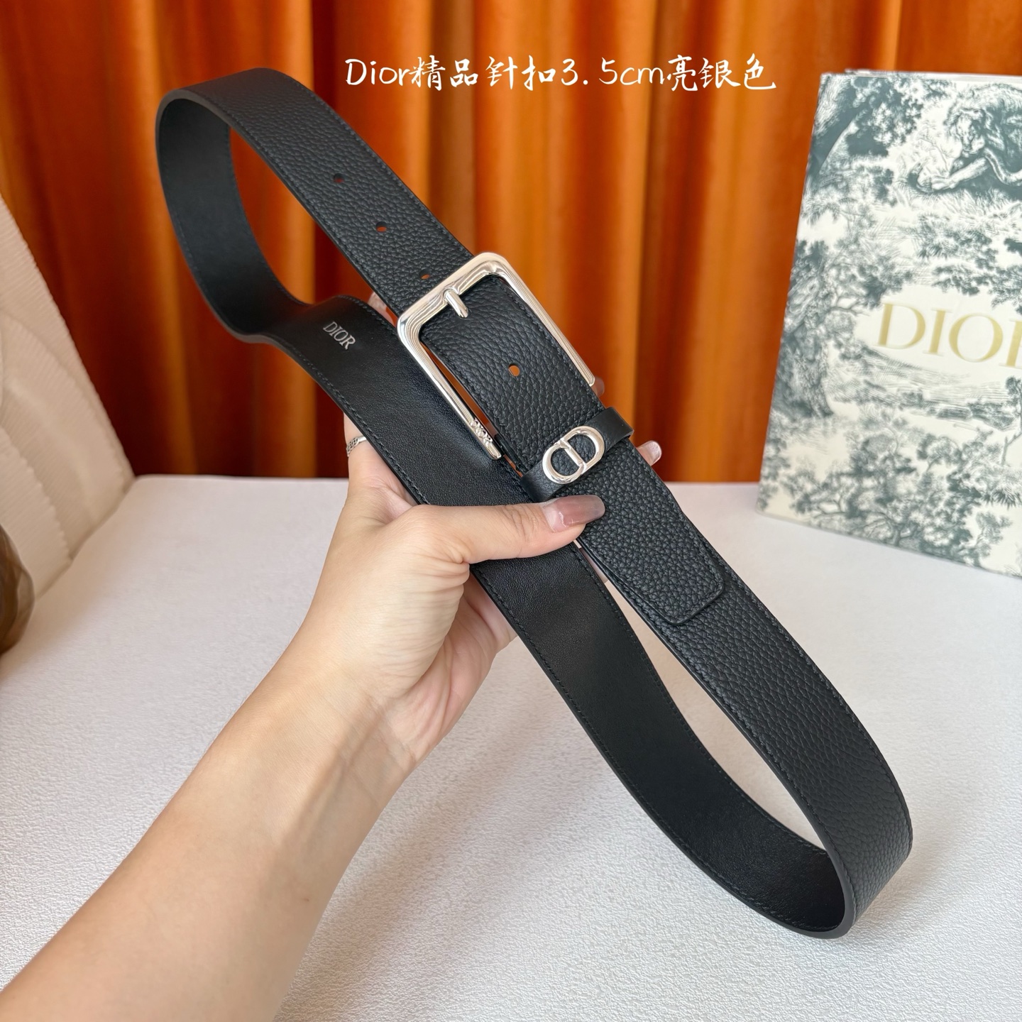 Dior这款腰带采用黑色粒面牛皮革精心制作，饰以镌刻有 Dior 的针扣和金属 CD Icon 标志腰带