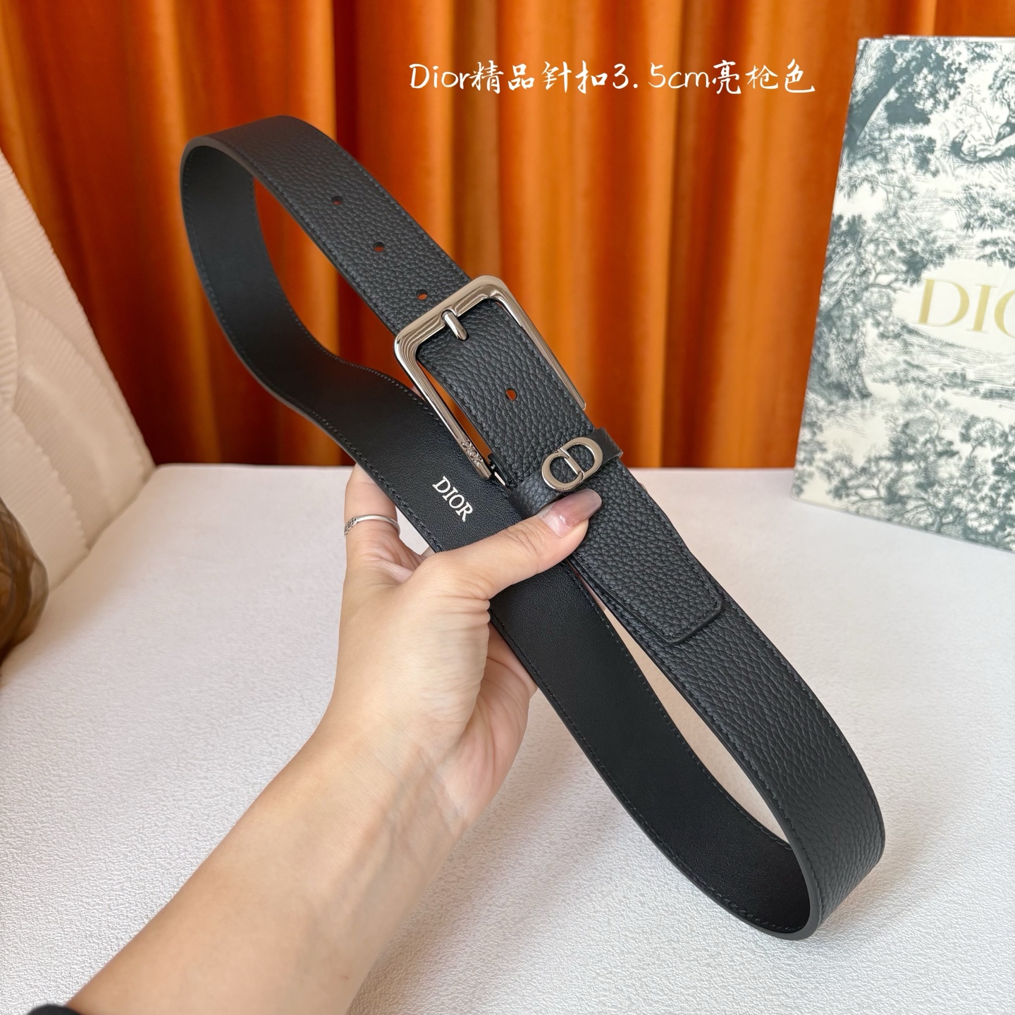 Dior这款腰带采用黑色粒面牛皮革精心制作，饰以镌刻有 Dior 的针扣和金属 CD Icon 标志腰带