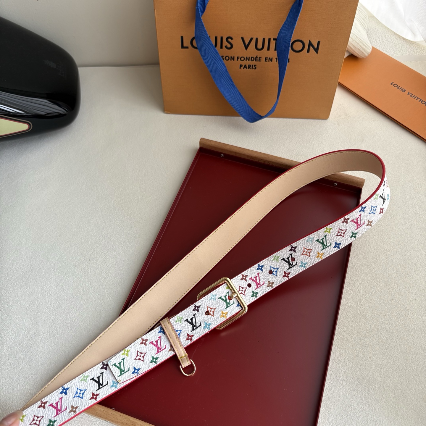 Lv3.0mm白彩双面腰带，以展现艺术家对品牌经典图案的灵动演绎，搭配针式搭扣和方便悬挂钥匙或装饰的D形
