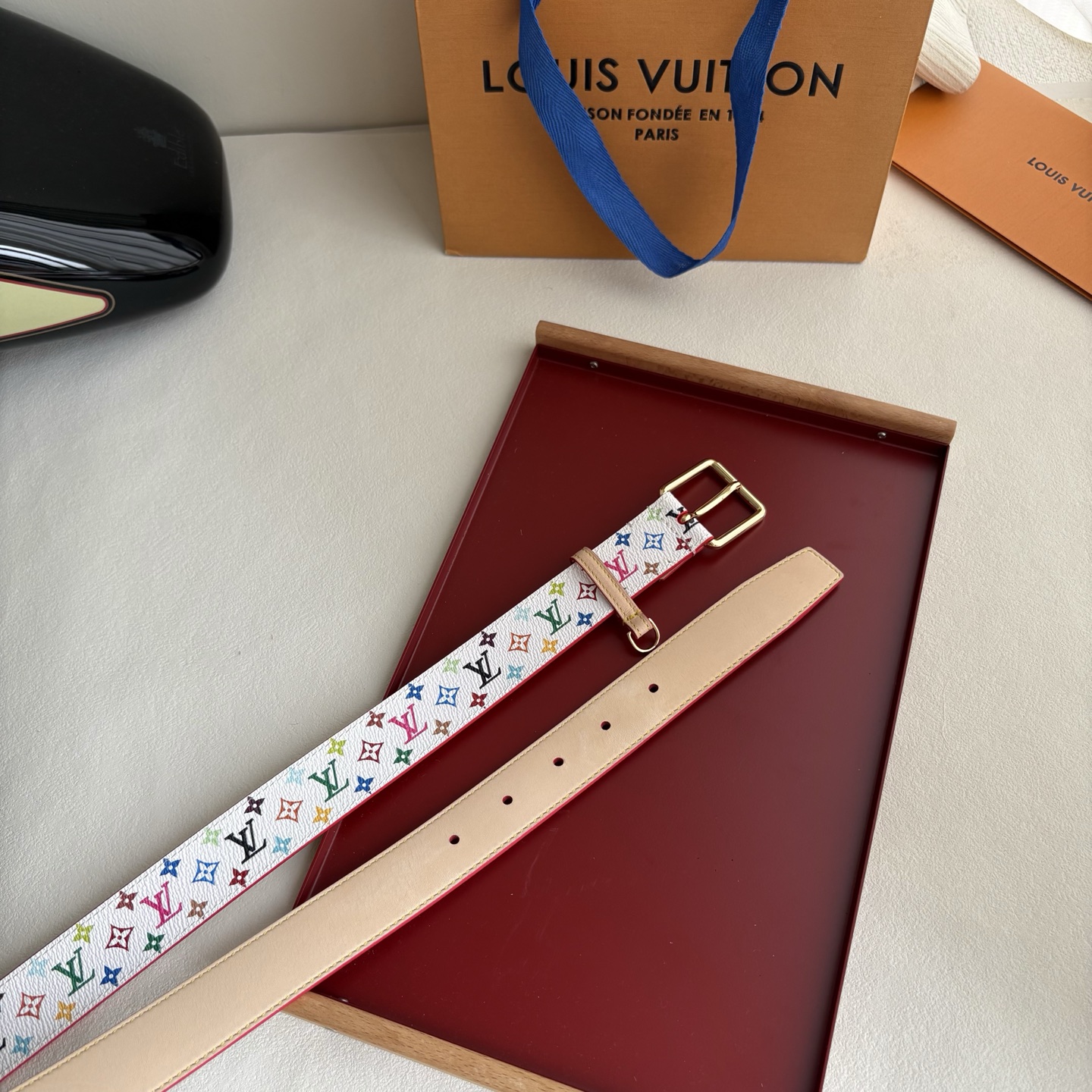 Lv3.0mm白彩双面腰带，以展现艺术家对品牌经典图案的灵动演绎，搭配针式搭扣和方便悬挂钥匙或装饰的D形