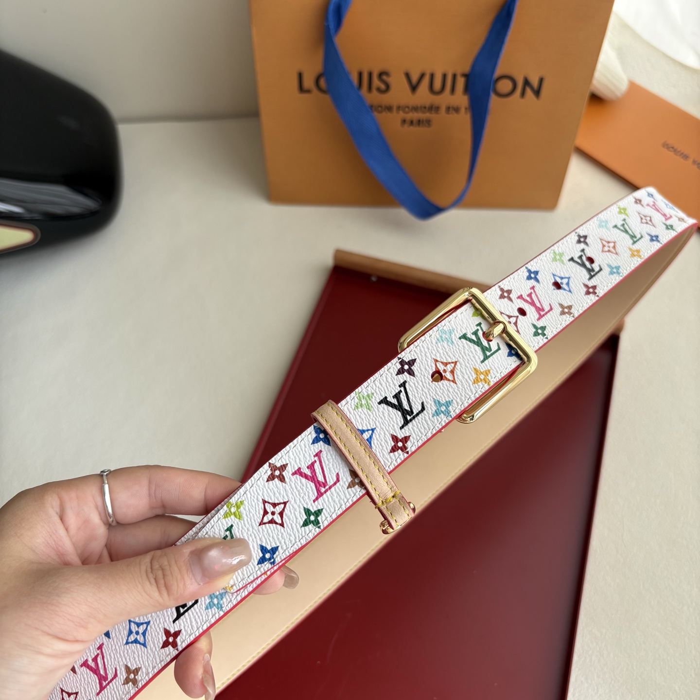 Lv3.0mm白彩双面腰带，以展现艺术家对品牌经典图案的灵动演绎，搭配针式搭扣和方便悬挂钥匙或装饰的D形