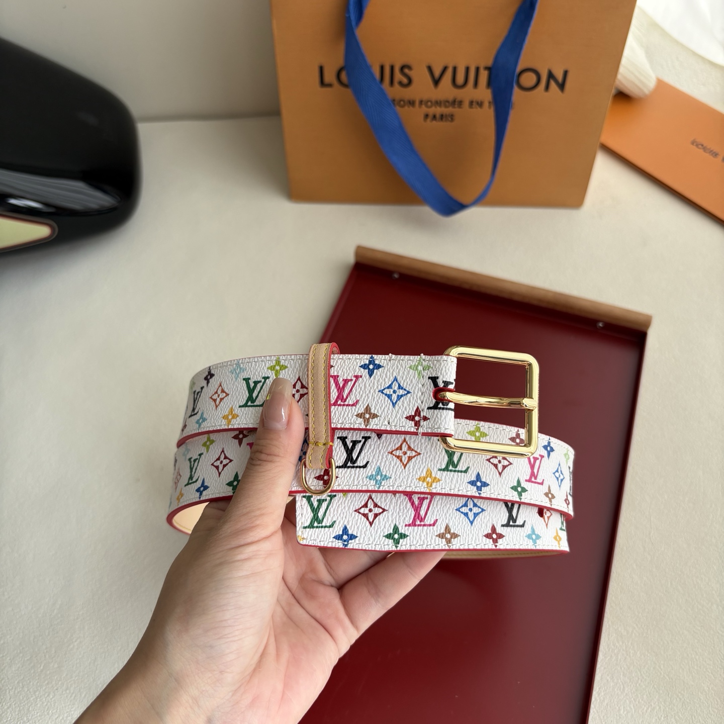Lv3.0mm白彩双面腰带，以展现艺术家对品牌经典图案的灵动演绎，搭配针式搭扣和方便悬挂钥匙或装饰的D形