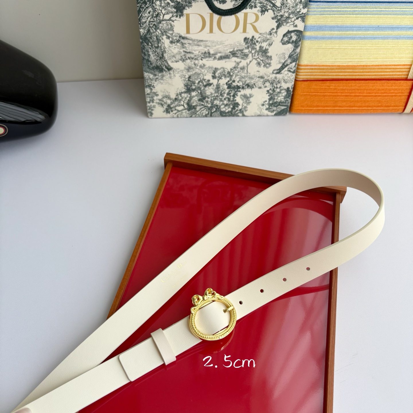Dior 腰带以十八世纪洛可可风格演绎 Dior 沙龙的精致格调。采用光滑牛皮革精心制作，搭配复古色饰面