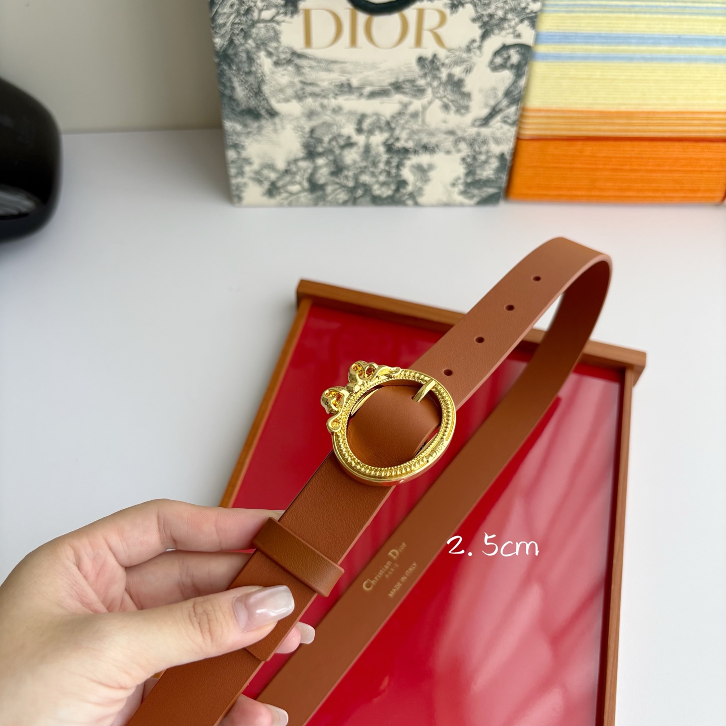Dior 腰带以十八世纪洛可可风格演绎 Dior 沙龙的精致格调。采用光滑牛皮革精心制作，搭配复古色饰面