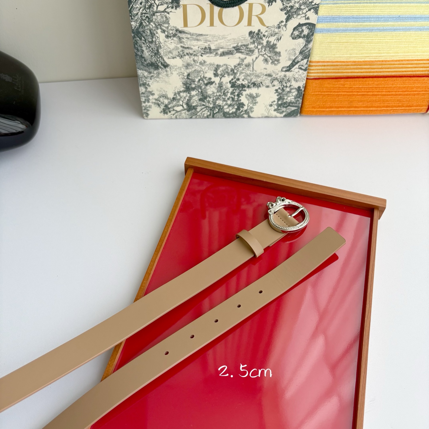 Dior 腰带以十八世纪洛可可风格演绎 Dior 沙龙的精致格调。采用光滑牛皮革精心制作，搭配复古色饰面