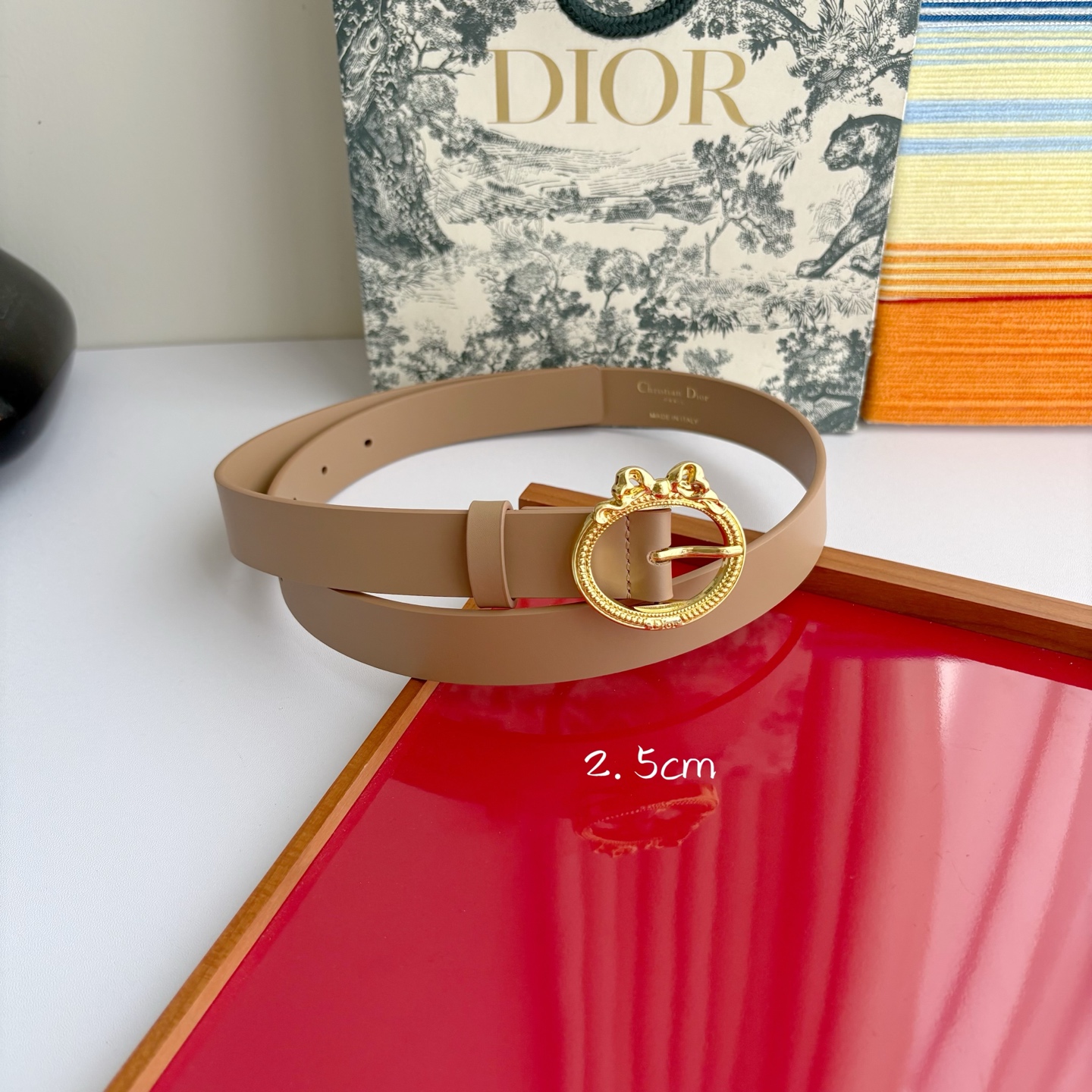 Dior 腰带以十八世纪洛可可风格演绎 Dior 沙龙的精致格调。采用光滑牛皮革精心制作，搭配复古色饰面