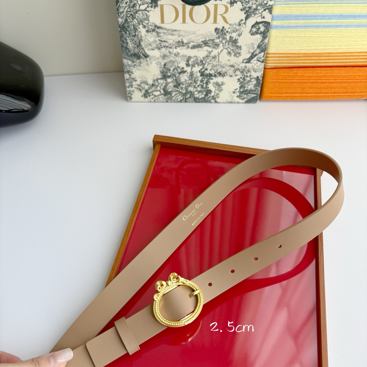 Dior 腰带以十八世纪洛可可风格演绎 Dior 沙龙的精致格调。采用光滑牛皮革精心制作，搭配复古色饰面