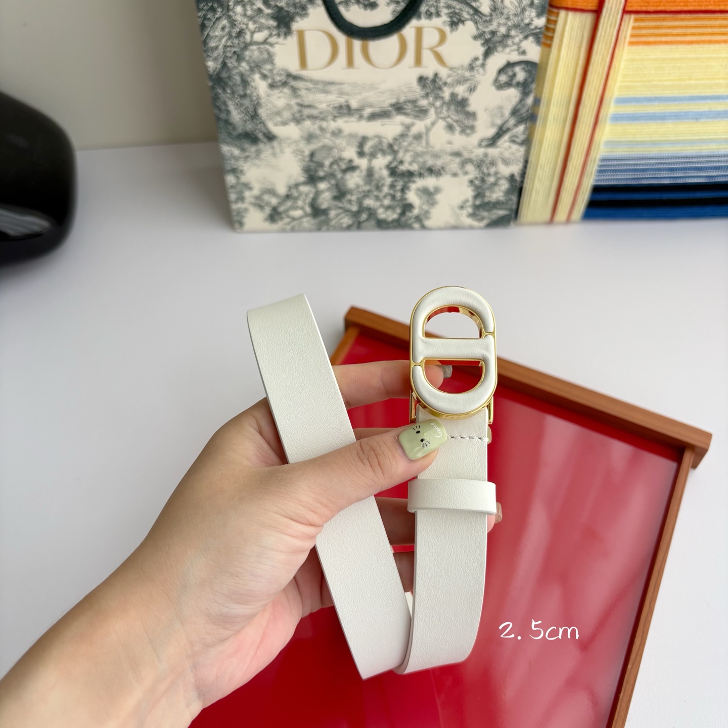 Dior这款腰带采用光滑牛皮革材质精心制作，搭配以富有光泽的复古金色饰面金属扣同色调牛皮革呈现的经典CD