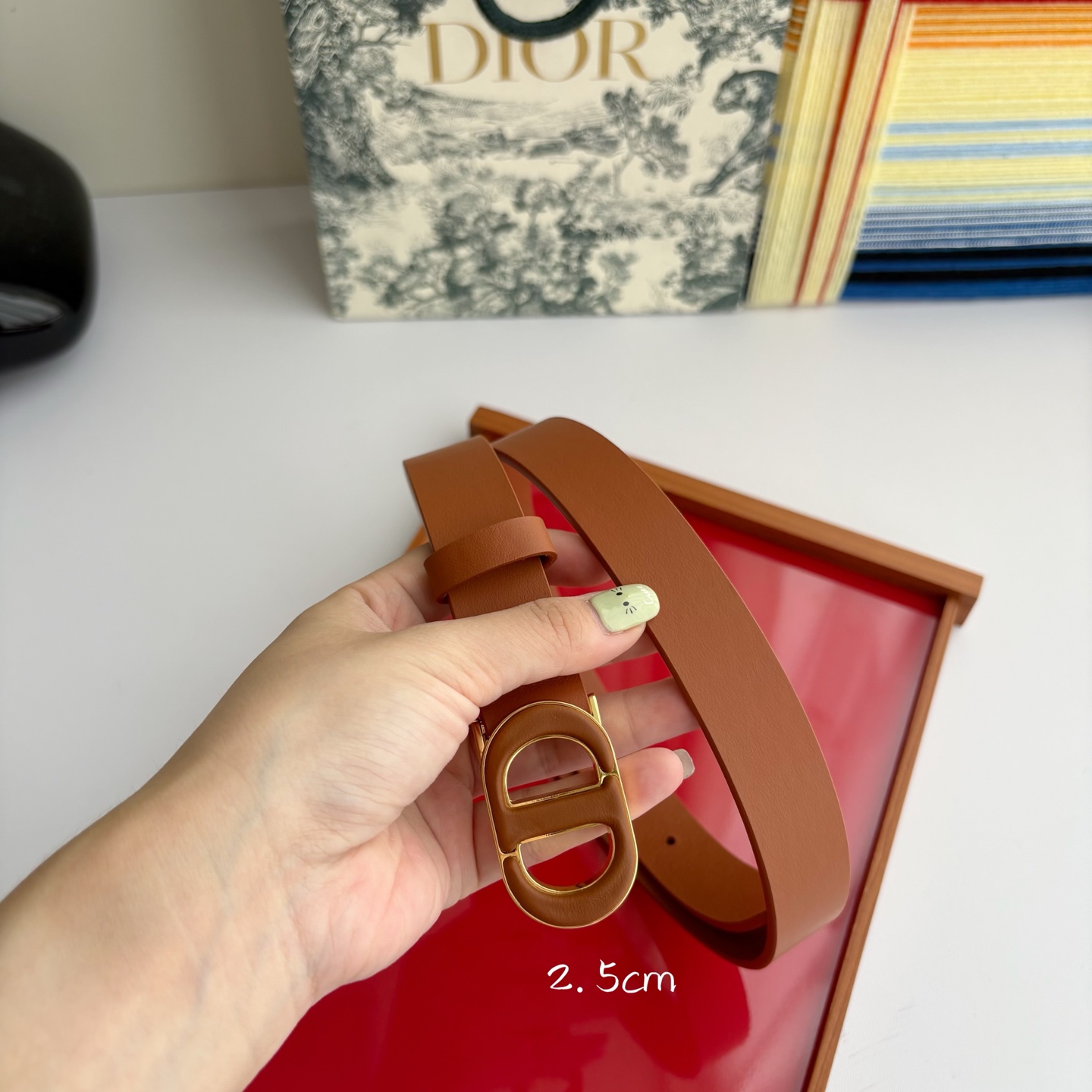 Dior这款腰带采用光滑牛皮革材质精心制作，搭配以富有光泽的复古金色饰面金属扣同色调牛皮革呈现的经典CD
