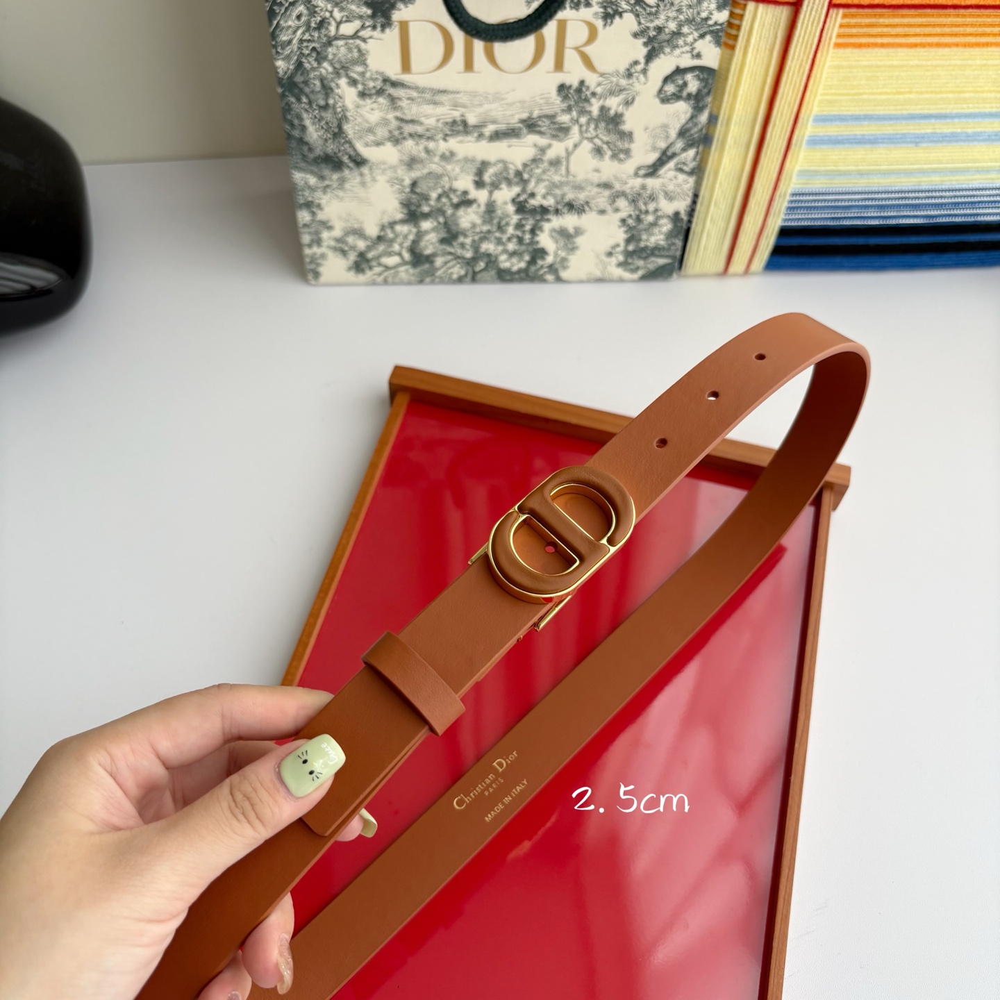 Dior这款腰带采用光滑牛皮革材质精心制作，搭配以富有光泽的复古金色饰面金属扣同色调牛皮革呈现的经典CD