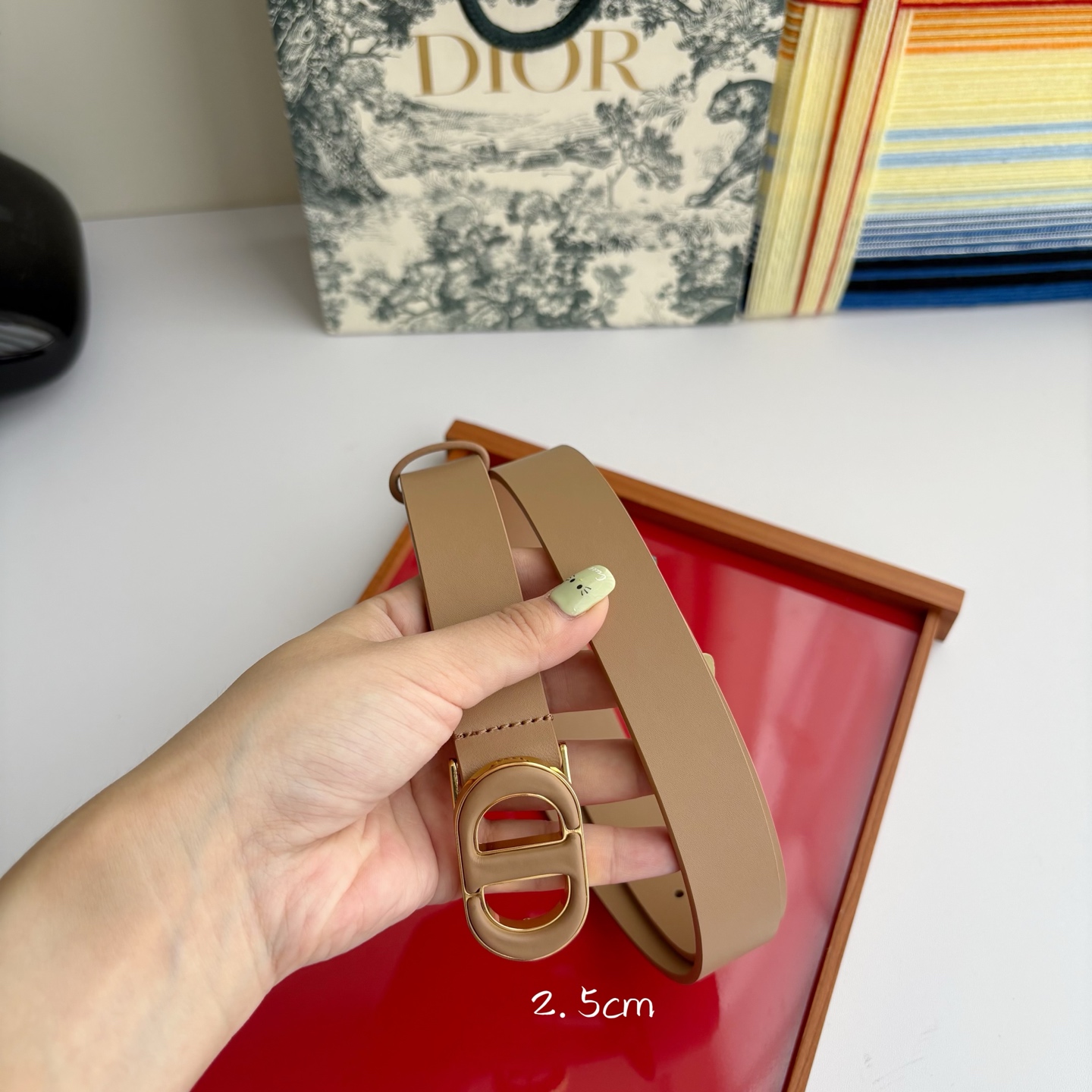 Dior这款腰带采用光滑牛皮革材质精心制作，搭配以富有光泽的复古金色饰面金属扣同色调牛皮革呈现的经典CD