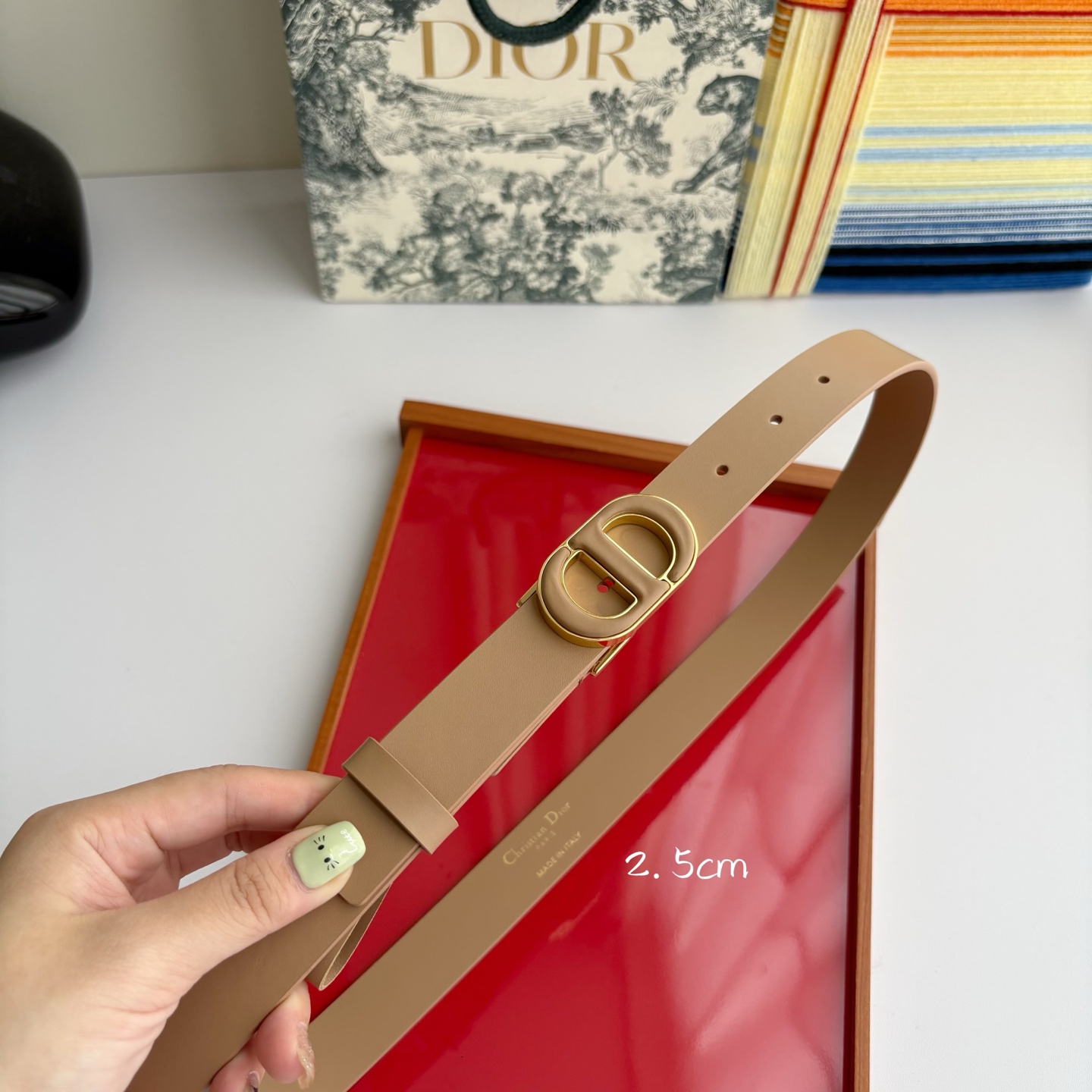 Dior这款腰带采用光滑牛皮革材质精心制作，搭配以富有光泽的复古金色饰面金属扣同色调牛皮革呈现的经典CD