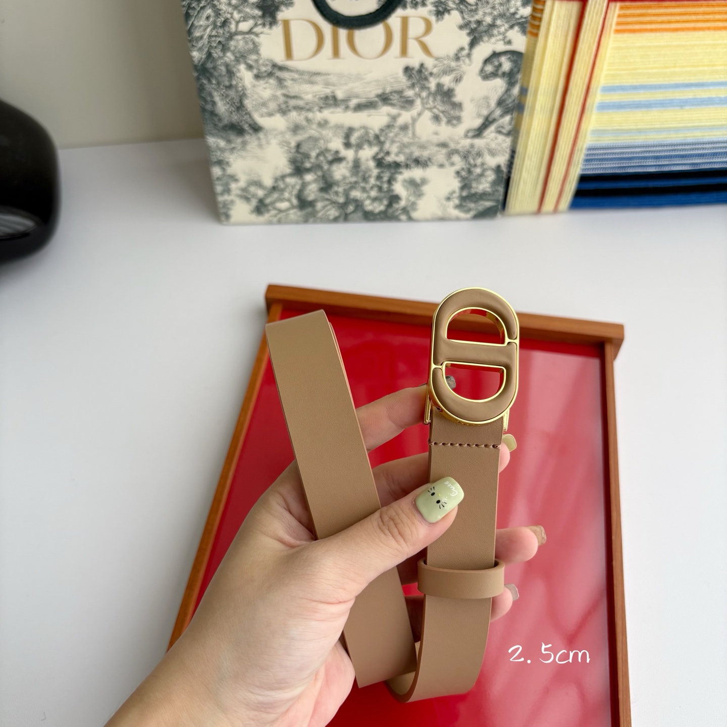 Dior这款腰带采用光滑牛皮革材质精心制作，搭配以富有光泽的复古金色饰面金属扣同色调牛皮革呈现的经典CD