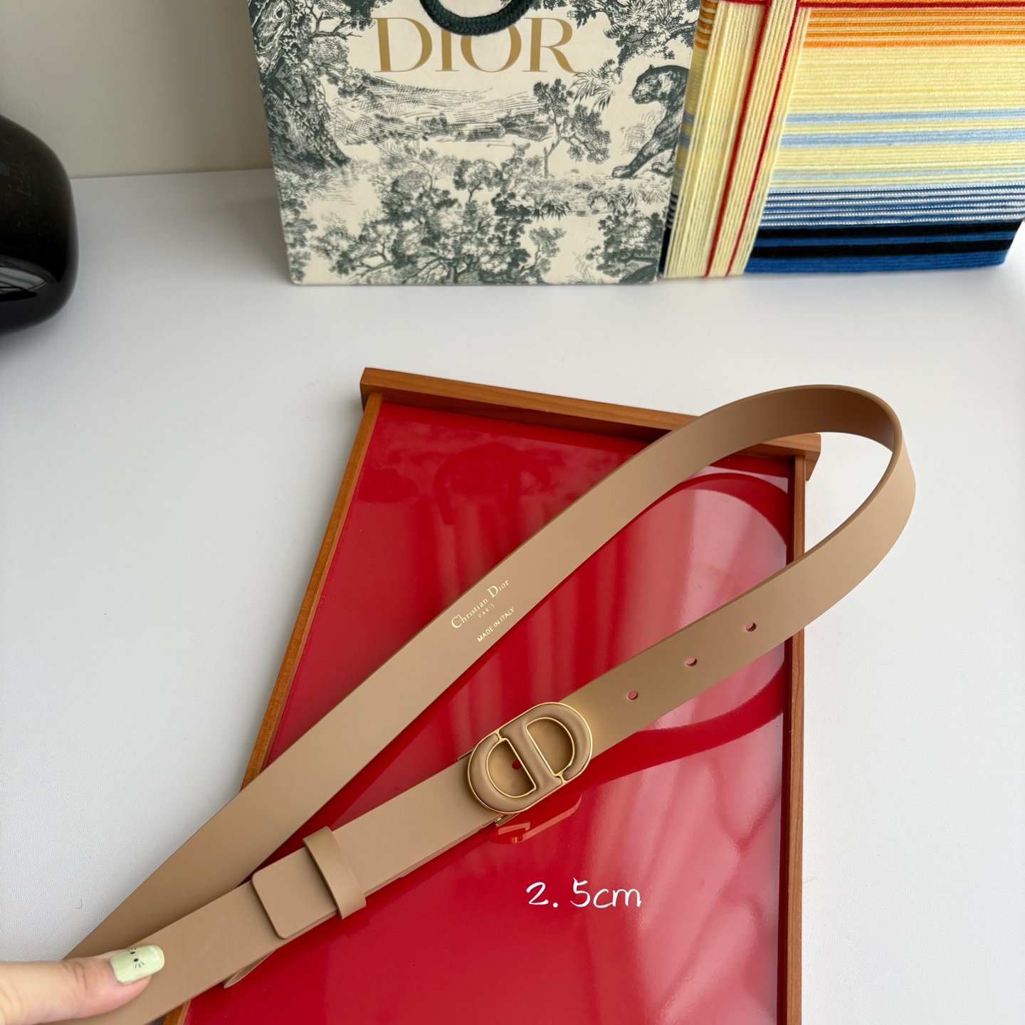 Dior这款腰带采用光滑牛皮革材质精心制作，搭配以富有光泽的复古金色饰面金属扣同色调牛皮革呈现的经典CD
