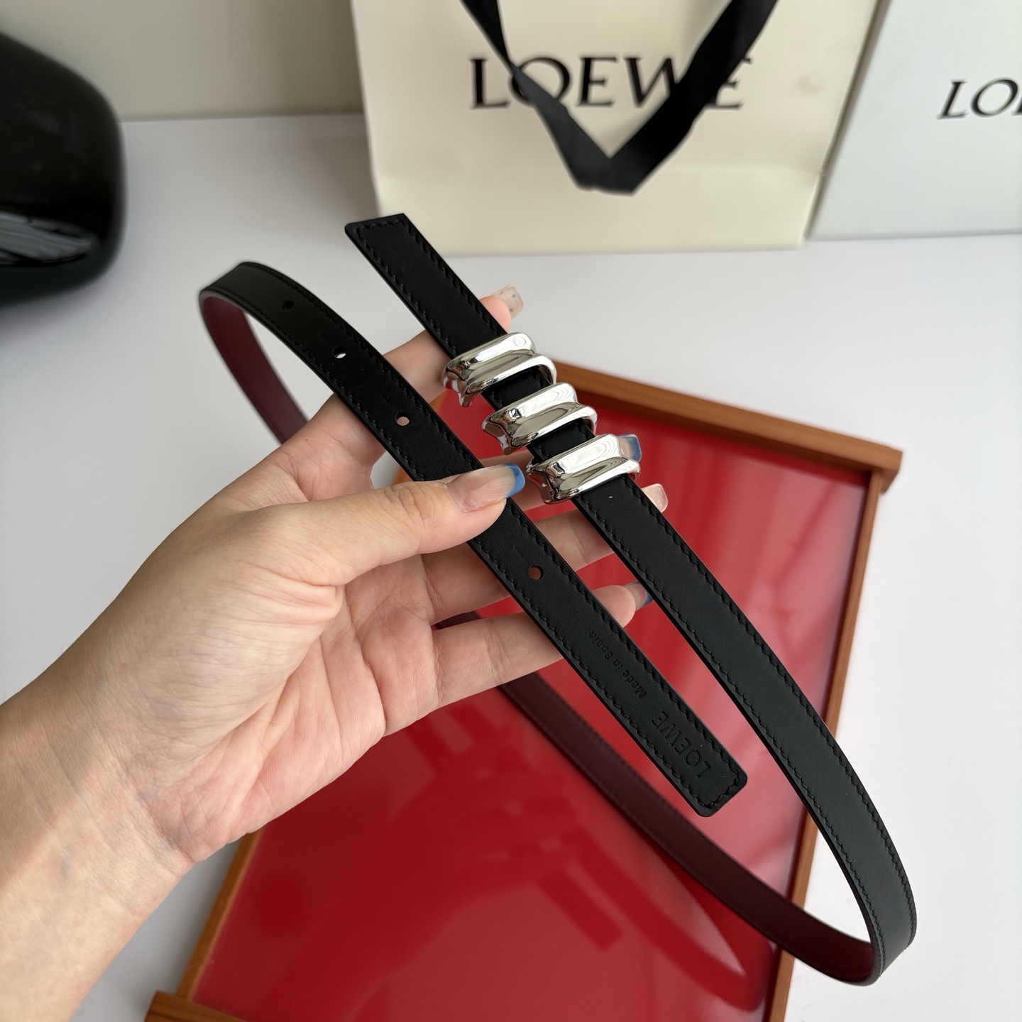 Loewe光滑牛皮革Coil双面腰带，饰有灵感源自品牌典藏的盘绕配件。Anchor腰带扣，宽1.5cm，五孔调节。黑色/