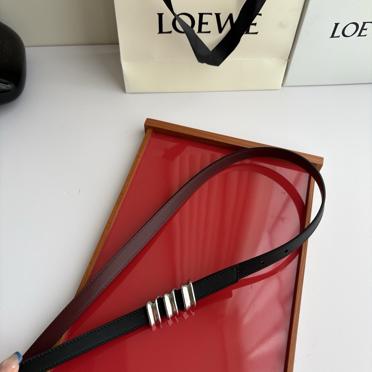Loewe光滑牛皮革Coil双面腰带，饰有灵感源自品牌典藏的盘绕配件。Anchor腰带扣，宽1.5cm，五孔调节。黑色/