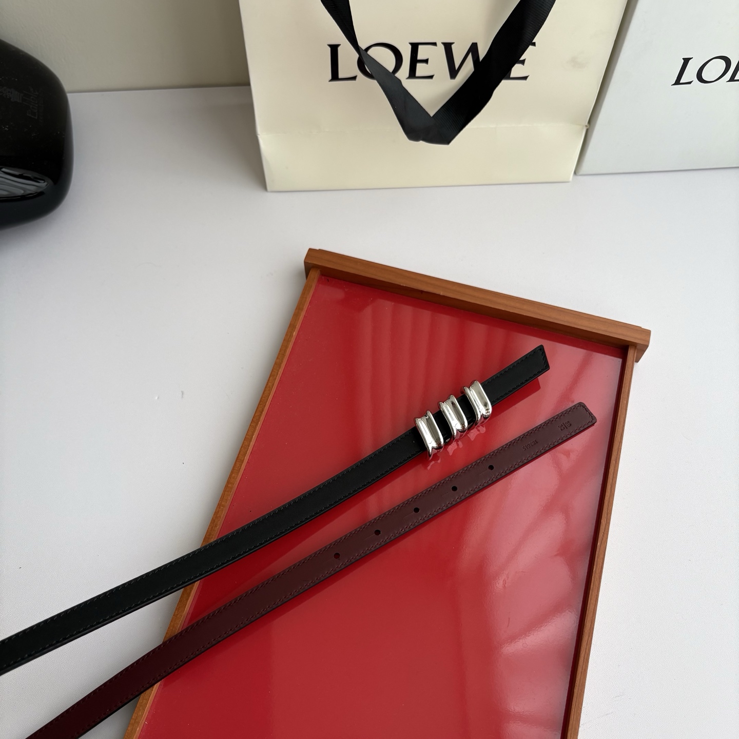 Loewe光滑牛皮革Coil双面腰带，饰有灵感源自品牌典藏的盘绕配件。Anchor腰带扣，宽1.5cm，五孔调节。黑色/