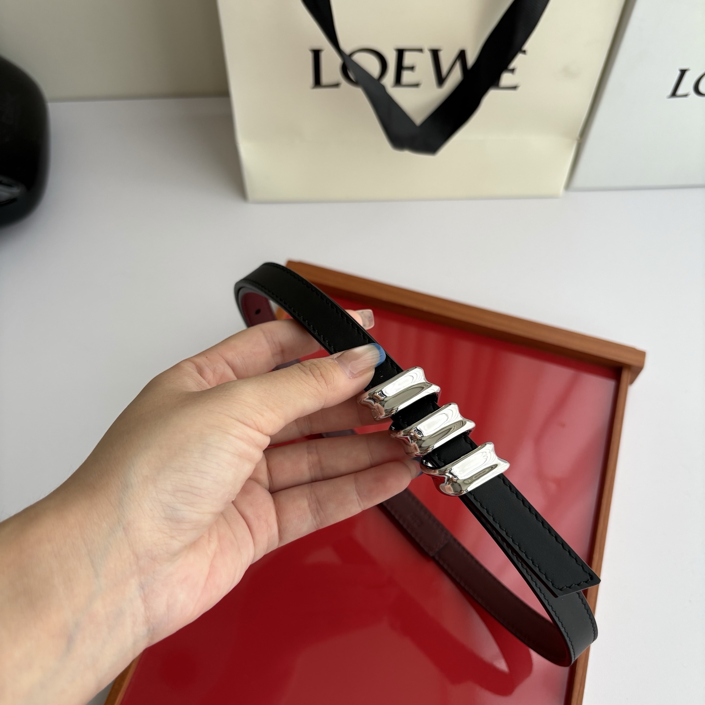 Loewe光滑牛皮革Coil双面腰带，饰有灵感源自品牌典藏的盘绕配件。Anchor腰带扣，宽1.5cm，五孔调节。黑色/