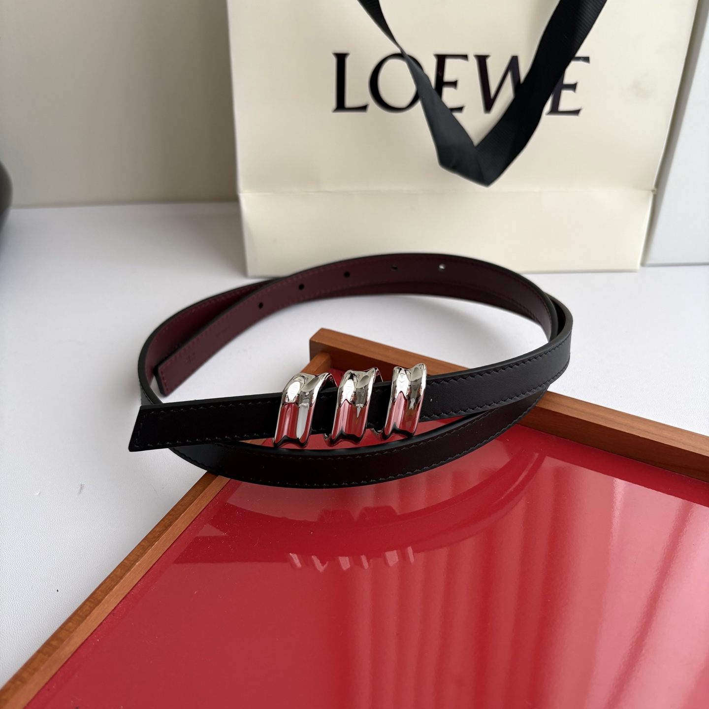 Loewe光滑牛皮革Coil双面腰带，饰有灵感源自品牌典藏的盘绕配件。Anchor腰带扣，宽1.5cm，五孔调节。黑色/