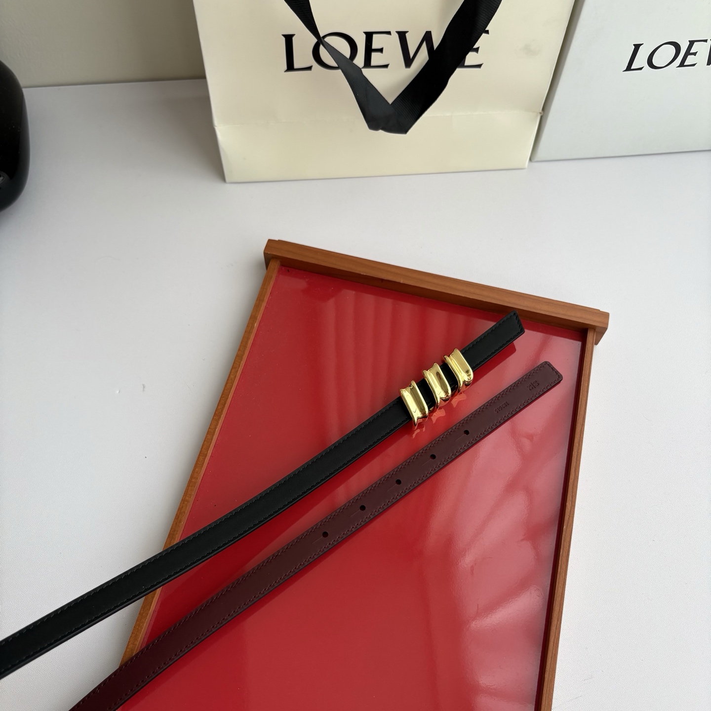 Loewe光滑牛皮革Coil双面腰带，饰有灵感源自品牌典藏的盘绕配件。Anchor腰带扣，宽1.5cm，五孔调节。黑色/