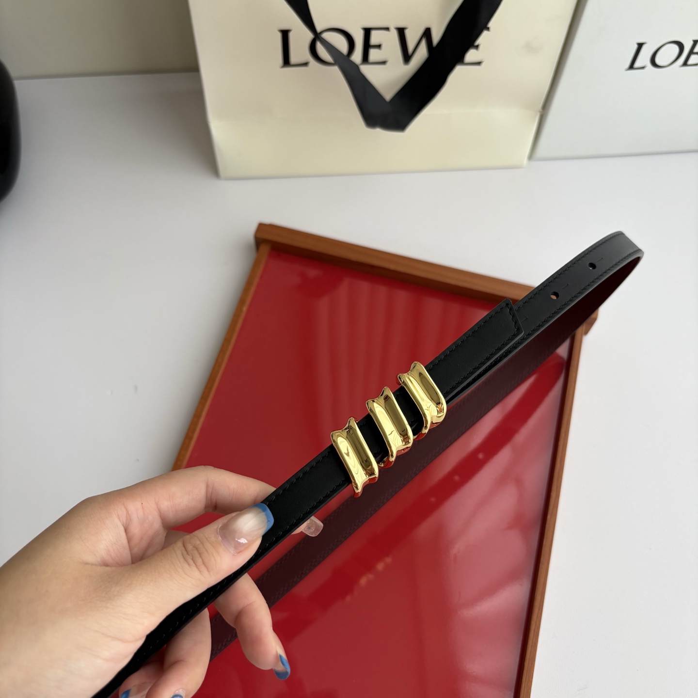 Loewe光滑牛皮革Coil双面腰带，饰有灵感源自品牌典藏的盘绕配件。Anchor腰带扣，宽1.5cm，五孔调节。黑色/