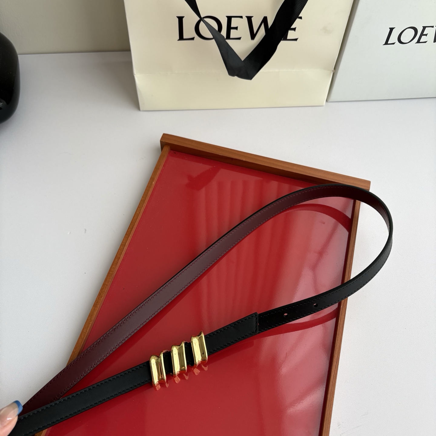 Loewe光滑牛皮革Coil双面腰带，饰有灵感源自品牌典藏的盘绕配件。Anchor腰带扣，宽1.5cm，五孔调节。黑色/