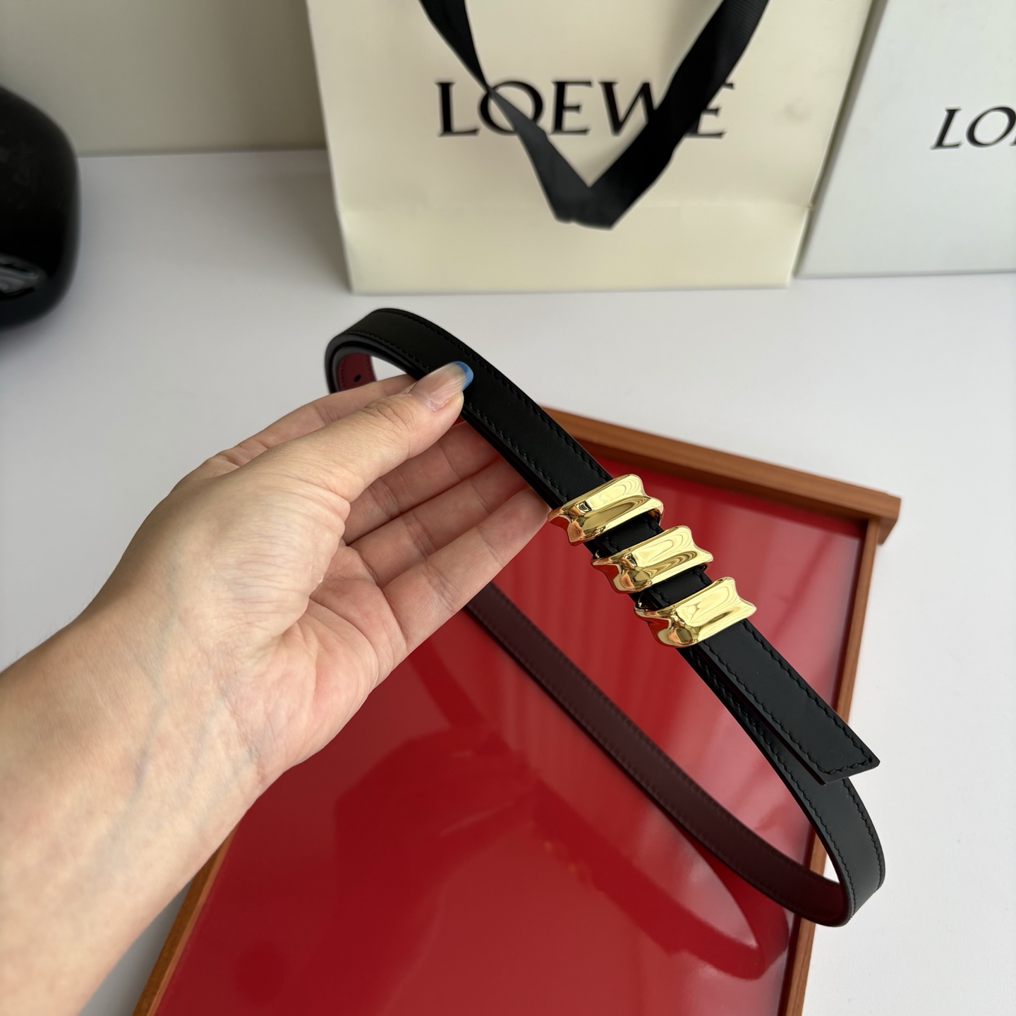 Loewe光滑牛皮革Coil双面腰带，饰有灵感源自品牌典藏的盘绕配件。Anchor腰带扣，宽1.5cm，五孔调节。黑色/