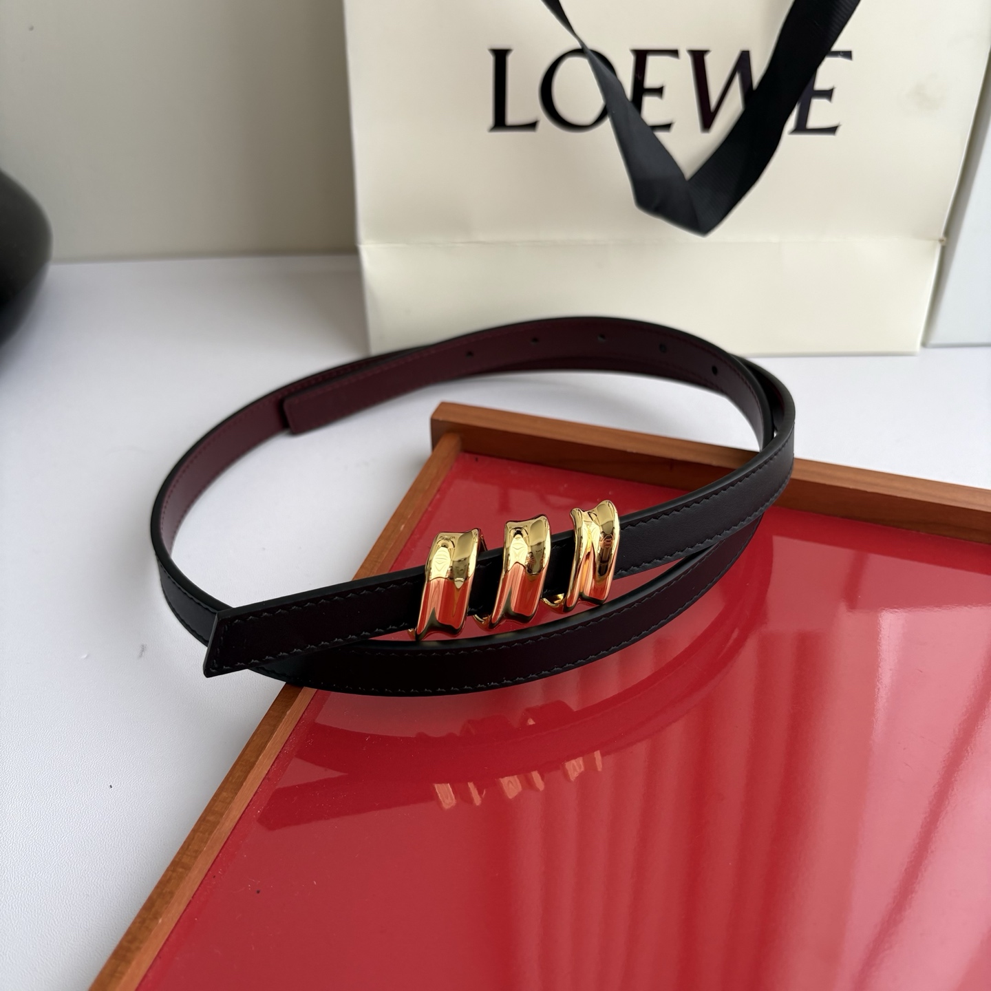 Loewe光滑牛皮革Coil双面腰带，饰有灵感源自品牌典藏的盘绕配件。Anchor腰带扣，宽1.5cm，五孔调节。黑色/