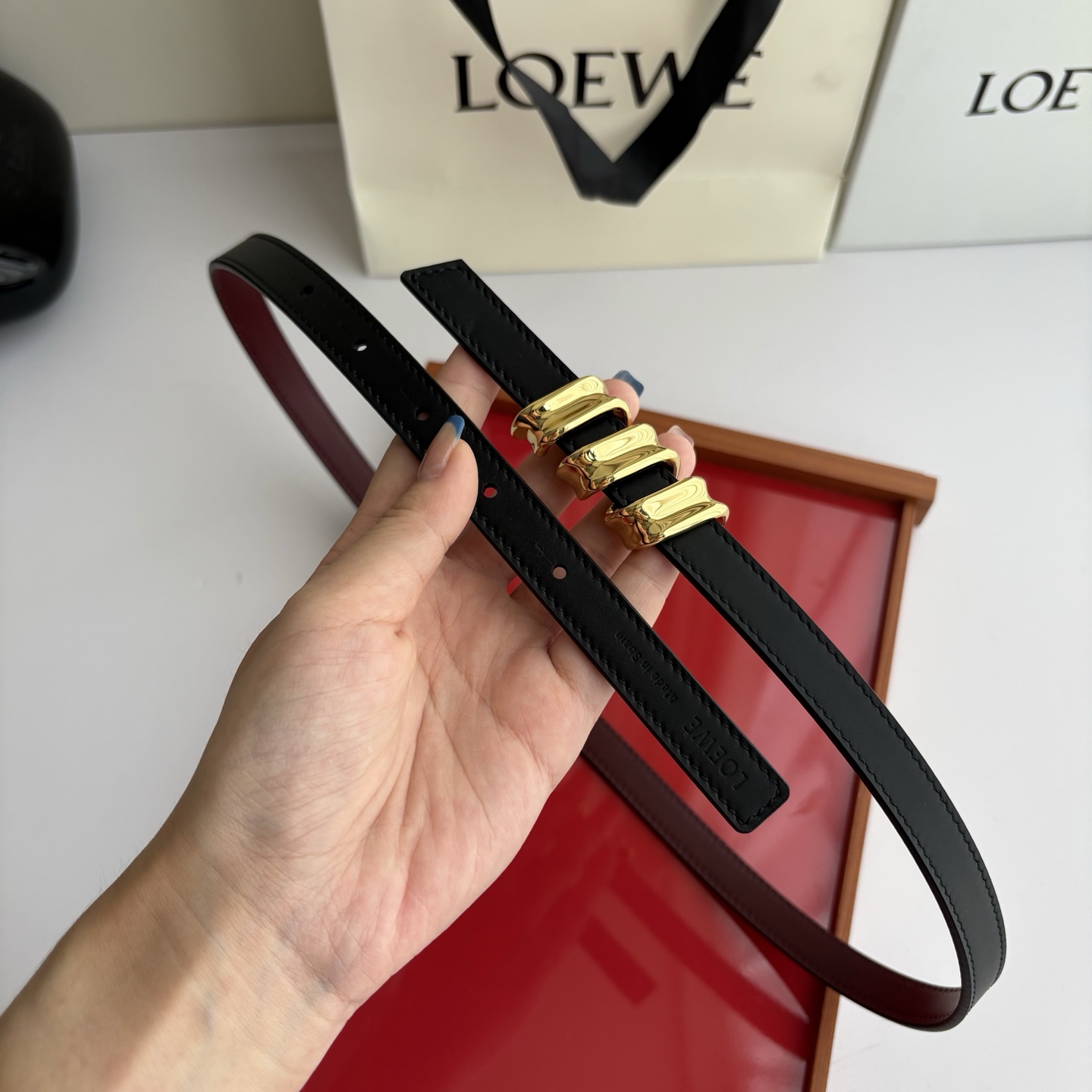 Loewe光滑牛皮革Coil双面腰带，饰有灵感源自品牌典藏的盘绕配件。Anchor腰带扣，宽1.5cm，五孔调节。黑色/