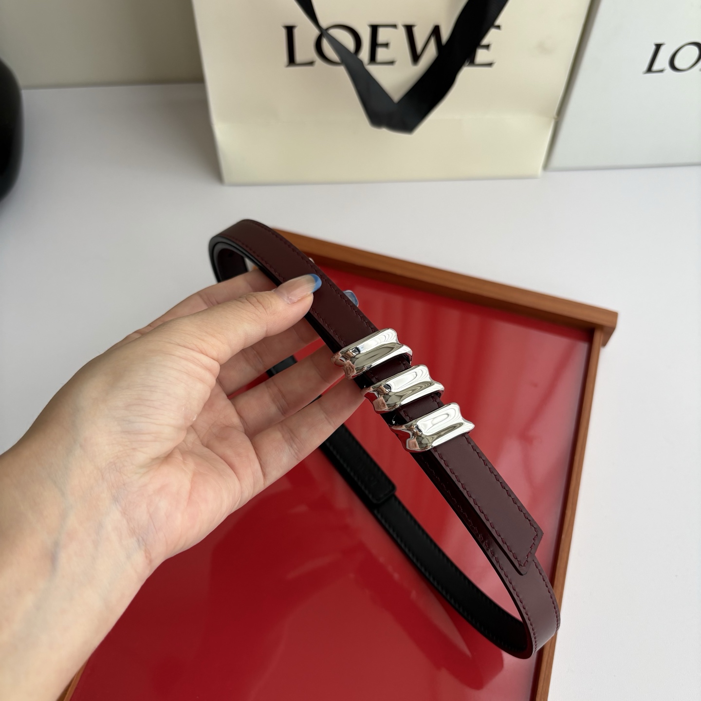 Loewe光滑牛皮革Coil双面腰带，饰有灵感源自品牌典藏的盘绕配件。Anchor腰带扣，宽1.5cm，五孔调节。黑色/