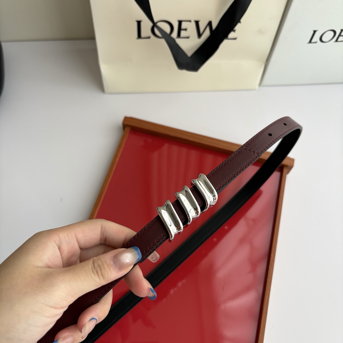 Loewe光滑牛皮革Coil双面腰带，饰有灵感源自品牌典藏的盘绕配件。Anchor腰带扣，宽1.5cm，五孔调节。黑色/