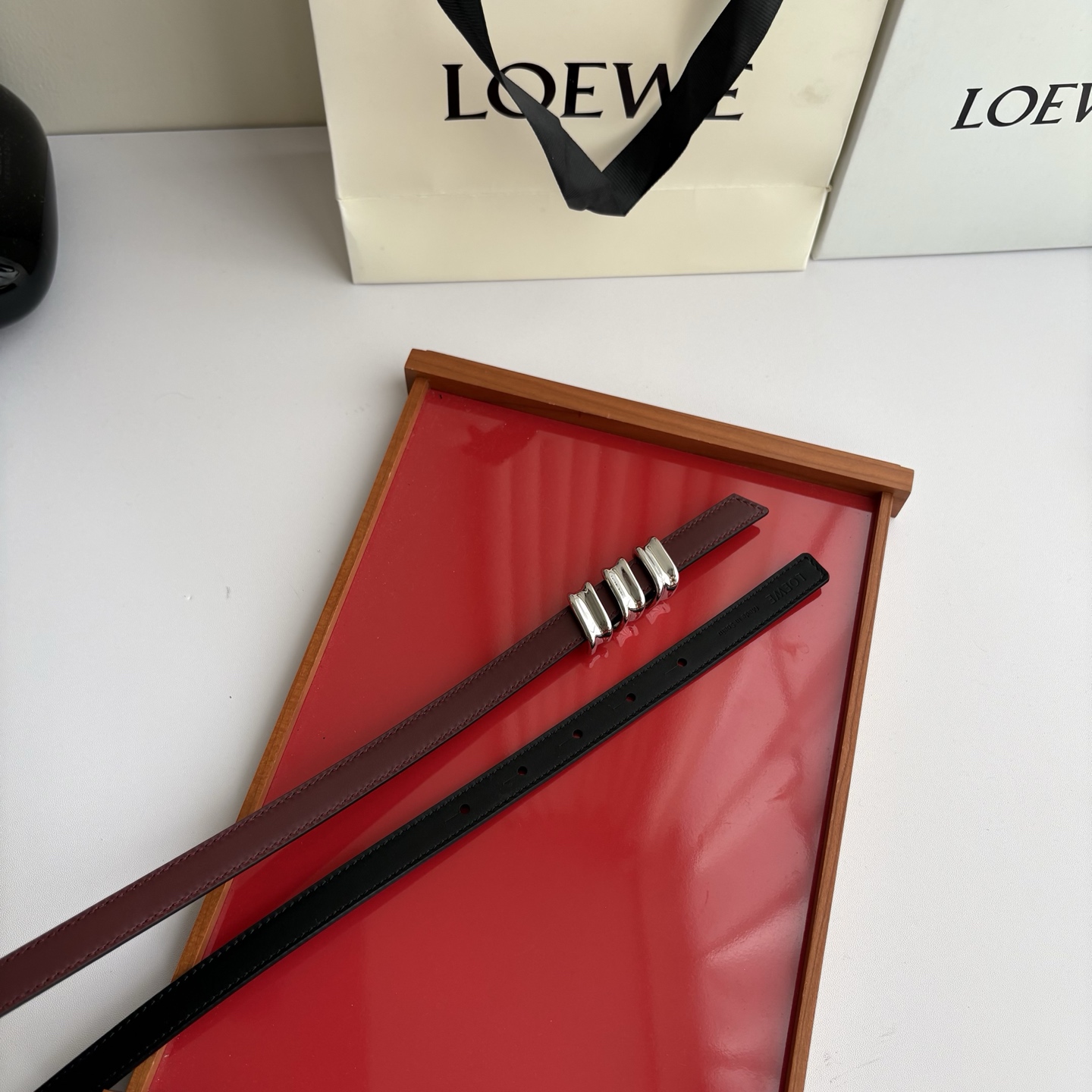 Loewe光滑牛皮革Coil双面腰带，饰有灵感源自品牌典藏的盘绕配件。Anchor腰带扣，宽1.5cm，五孔调节。黑色/