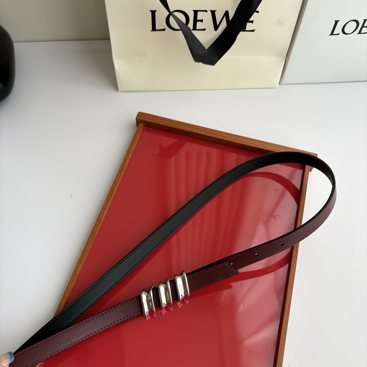 Loewe光滑牛皮革Coil双面腰带，饰有灵感源自品牌典藏的盘绕配件。Anchor腰带扣，宽1.5cm，五孔调节。黑色/