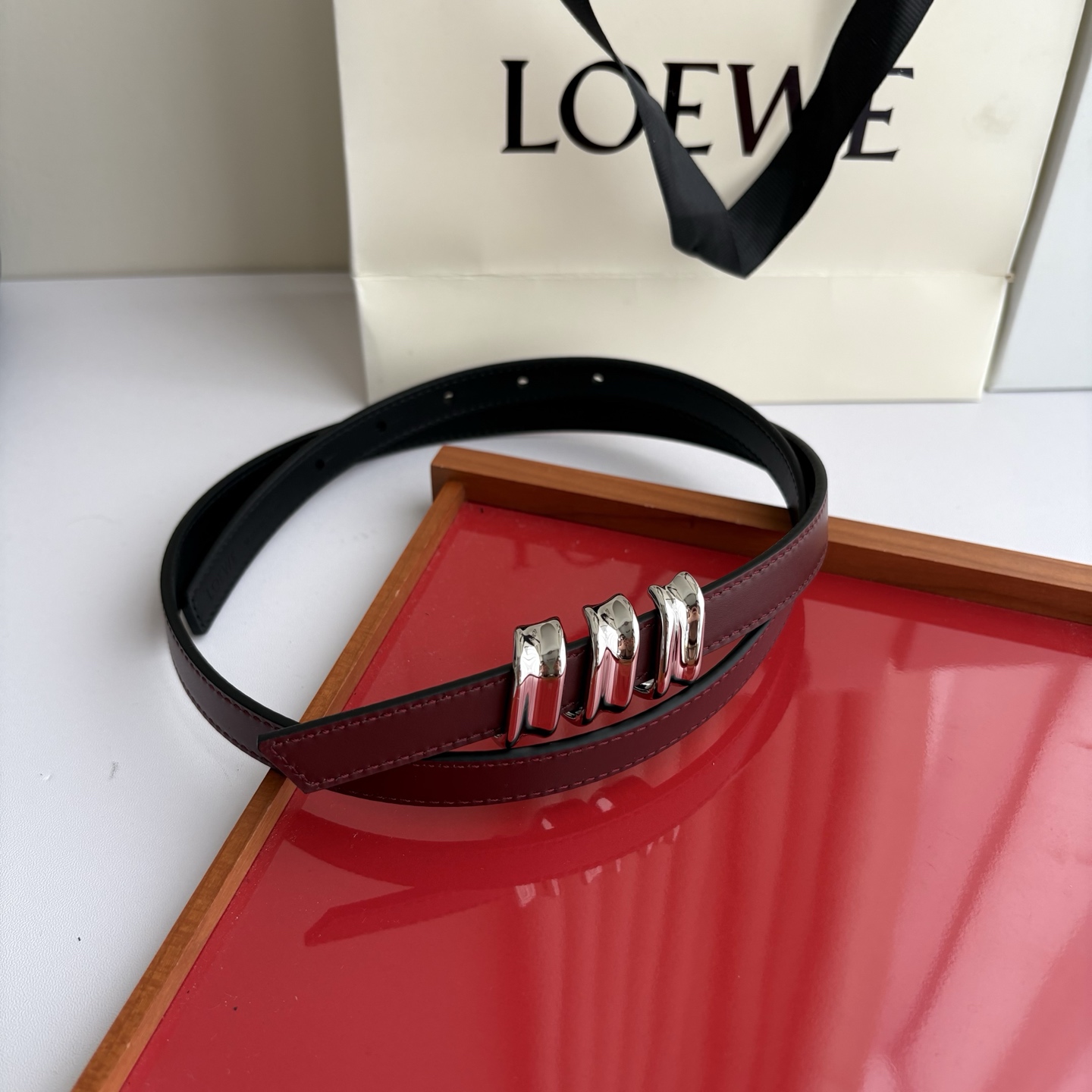 Loewe光滑牛皮革Coil双面腰带，饰有灵感源自品牌典藏的盘绕配件。Anchor腰带扣，宽1.5cm，五孔调节。黑色/