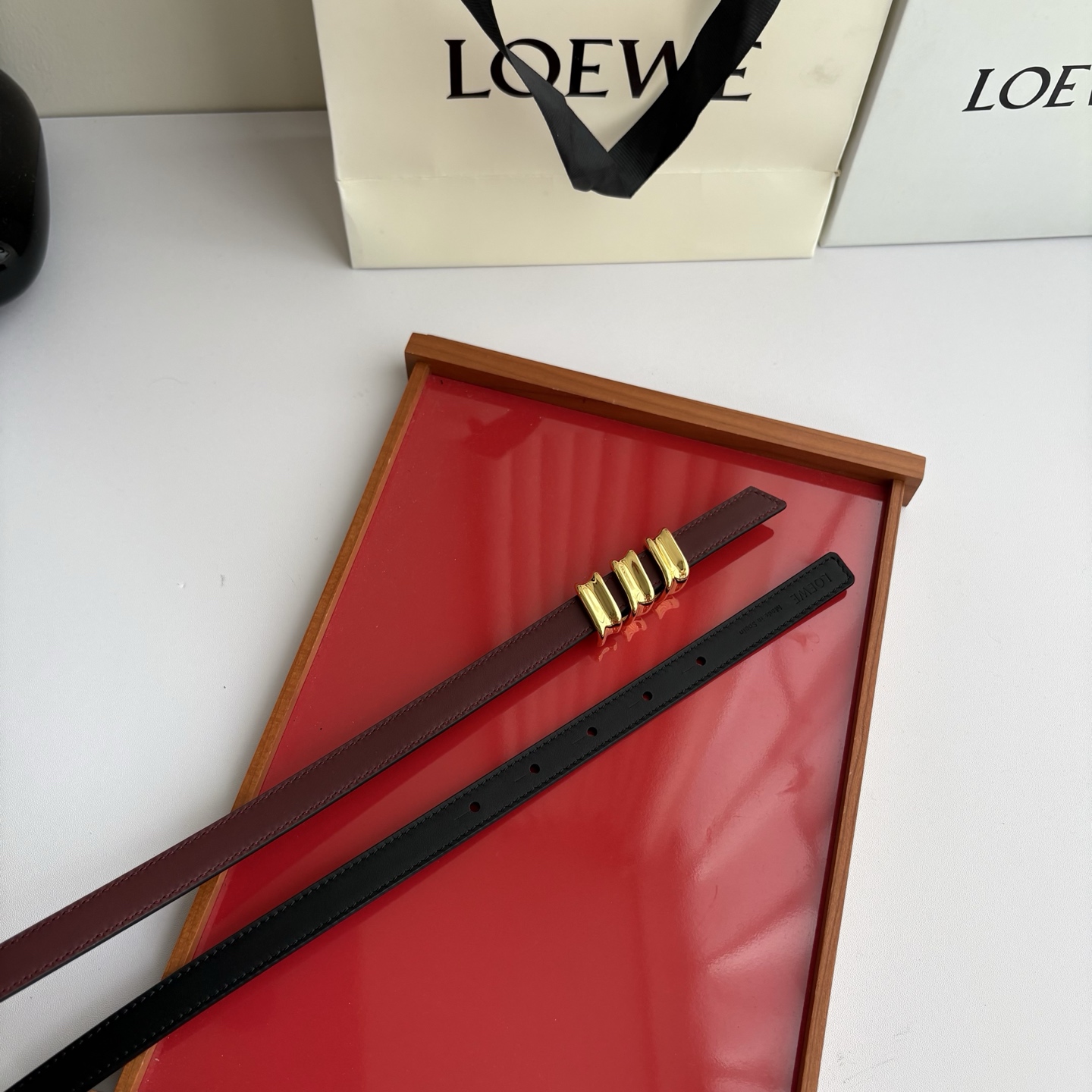 Loewe光滑牛皮革Coil双面腰带，饰有灵感源自品牌典藏的盘绕配件。Anchor腰带扣，宽1.5cm，五孔调节。黑色/