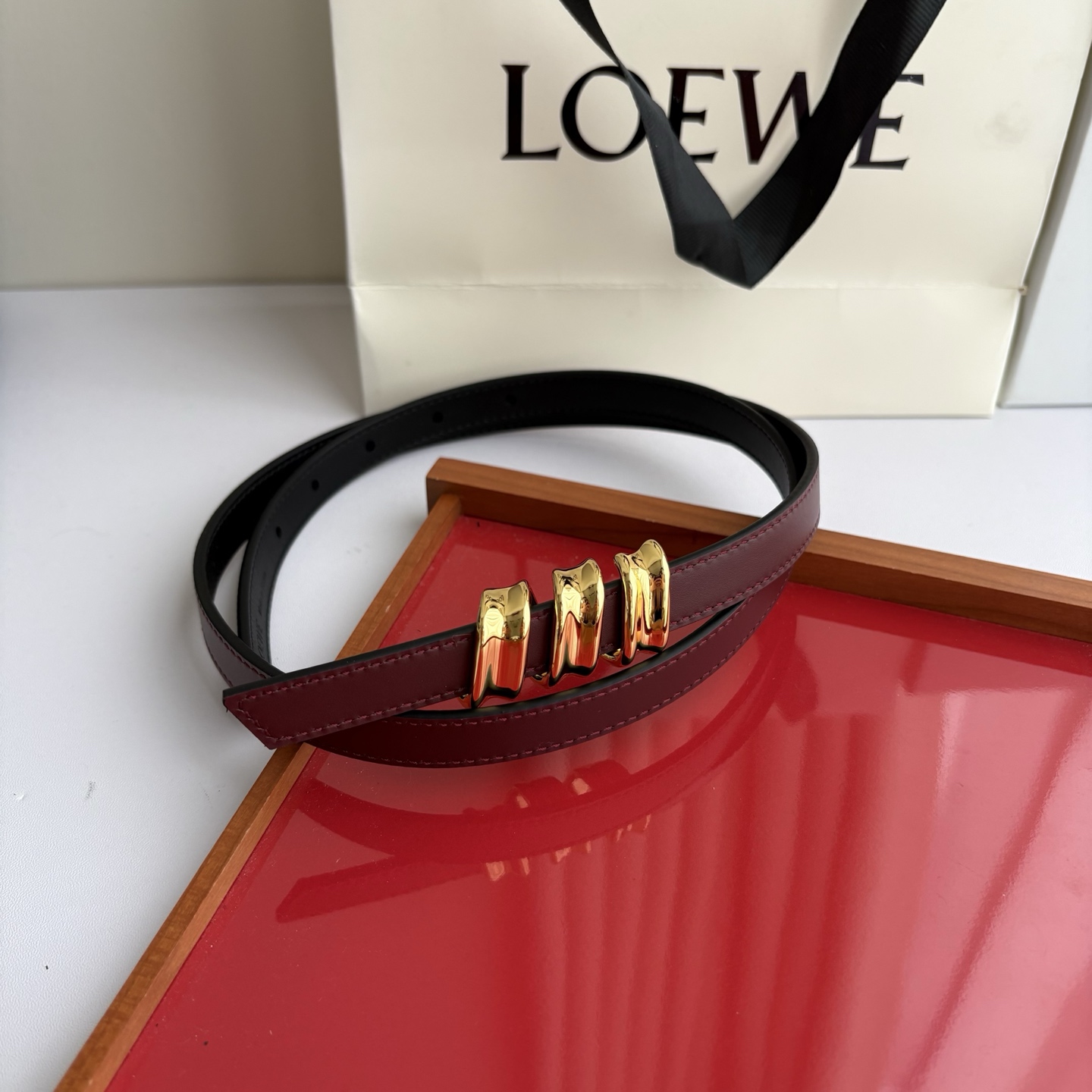 Loewe光滑牛皮革Coil双面腰带，饰有灵感源自品牌典藏的盘绕配件。Anchor腰带扣，宽1.5cm，五孔调节。黑色/