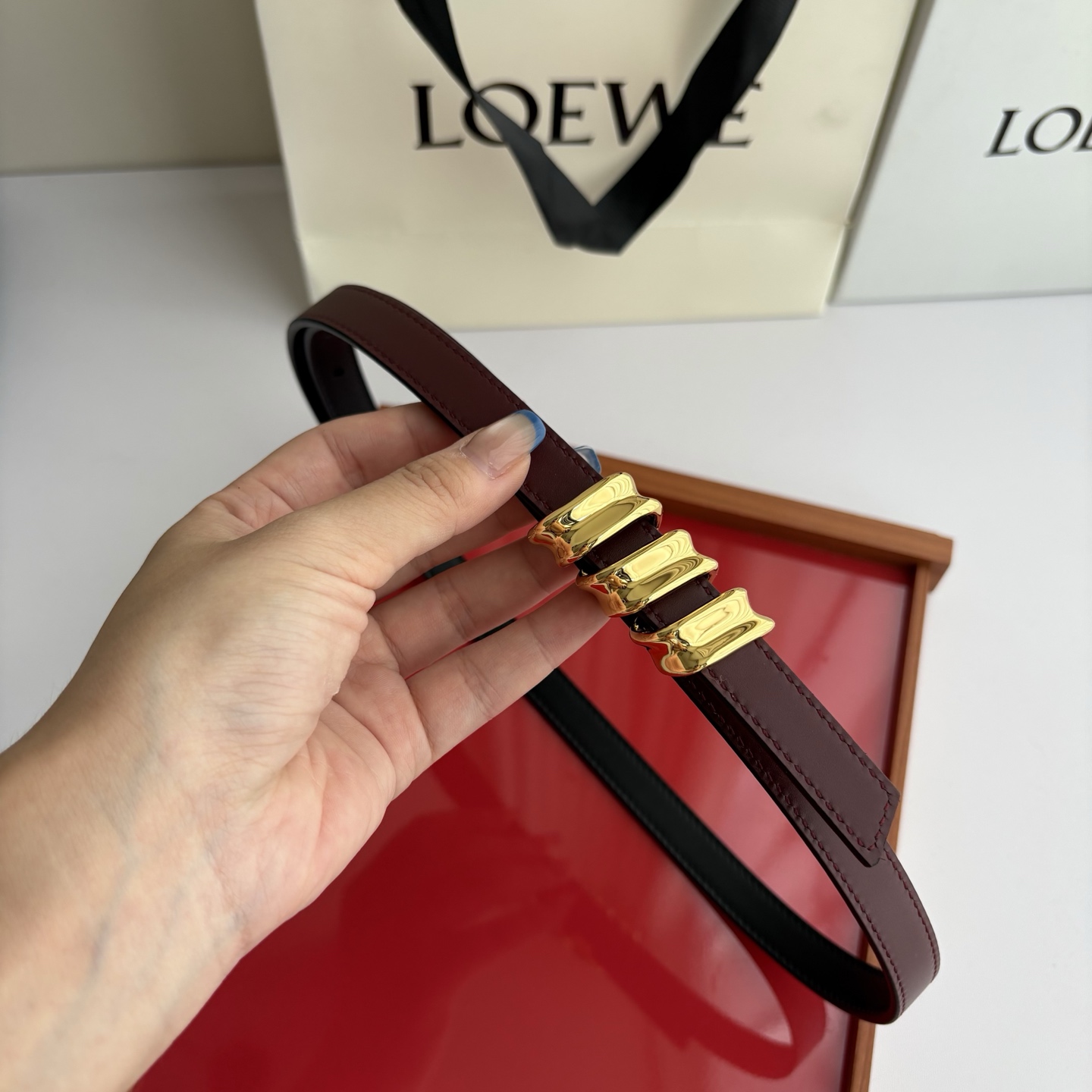 Loewe光滑牛皮革Coil双面腰带，饰有灵感源自品牌典藏的盘绕配件。Anchor腰带扣，宽1.5cm，五孔调节。黑色/