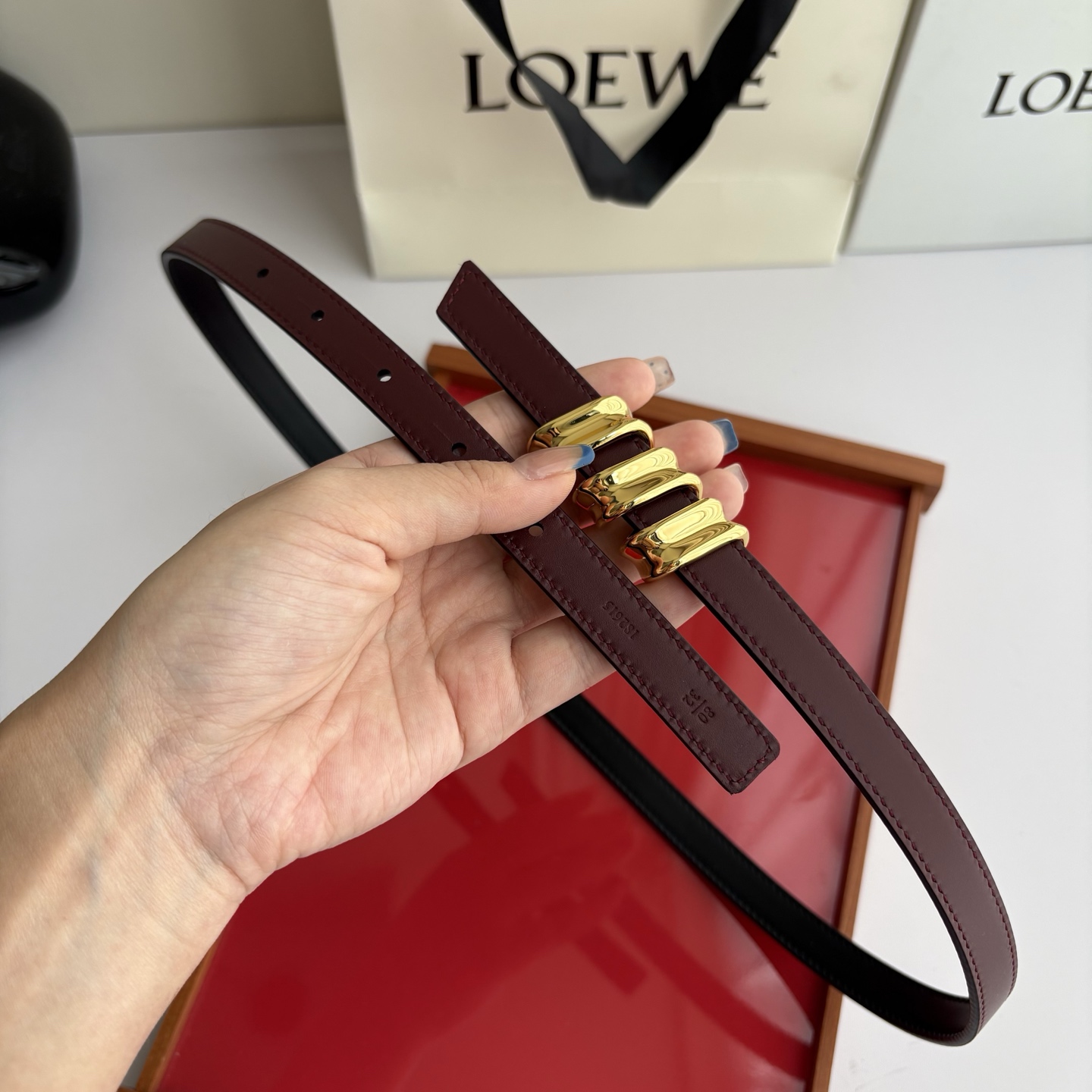 Loewe光滑牛皮革Coil双面腰带，饰有灵感源自品牌典藏的盘绕配件。Anchor腰带扣，宽1.5cm，五孔调节。黑色/