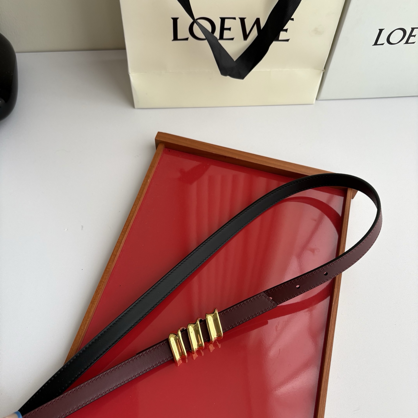 Loewe光滑牛皮革Coil双面腰带，饰有灵感源自品牌典藏的盘绕配件。Anchor腰带扣，宽1.5cm，五孔调节。黑色/