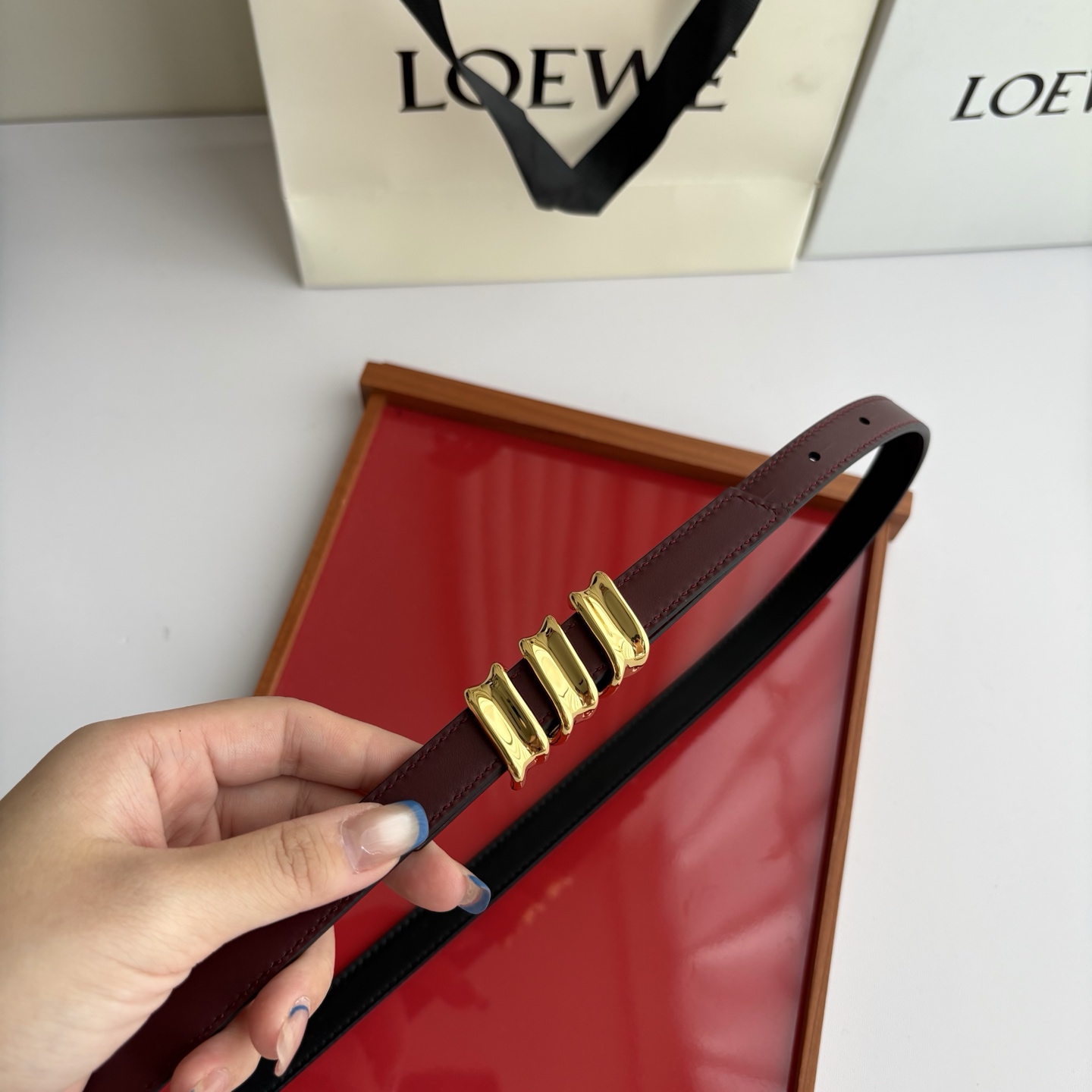Loewe光滑牛皮革Coil双面腰带，饰有灵感源自品牌典藏的盘绕配件。Anchor腰带扣，宽1.5cm，五孔调节。黑色/