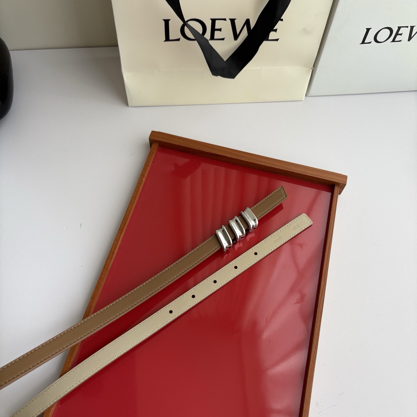 Loewe光滑牛皮革Coil双面腰带，饰有灵感源自品牌典藏的盘绕配件。Anchor腰带扣，宽1.5cm，五孔调节。摩卡色