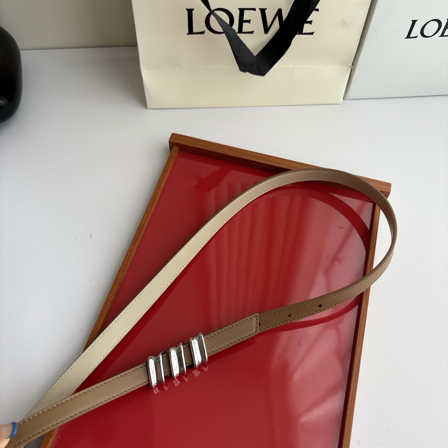 Loewe光滑牛皮革Coil双面腰带，饰有灵感源自品牌典藏的盘绕配件。Anchor腰带扣，宽1.5cm，五孔调节。摩卡色