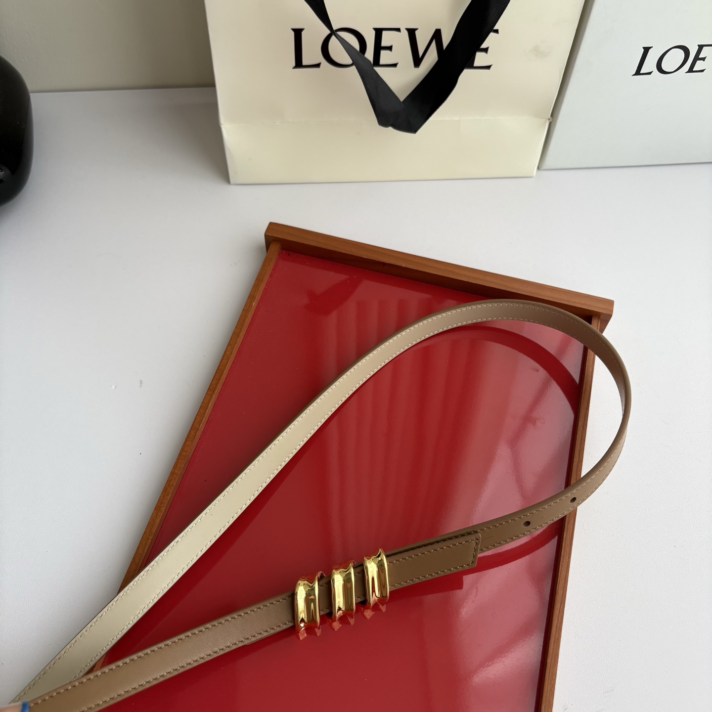Loewe光滑牛皮革Coil双面腰带，饰有灵感源自品牌典藏的盘绕配件。Anchor腰带扣，宽1.5cm，五孔调节。摩卡色