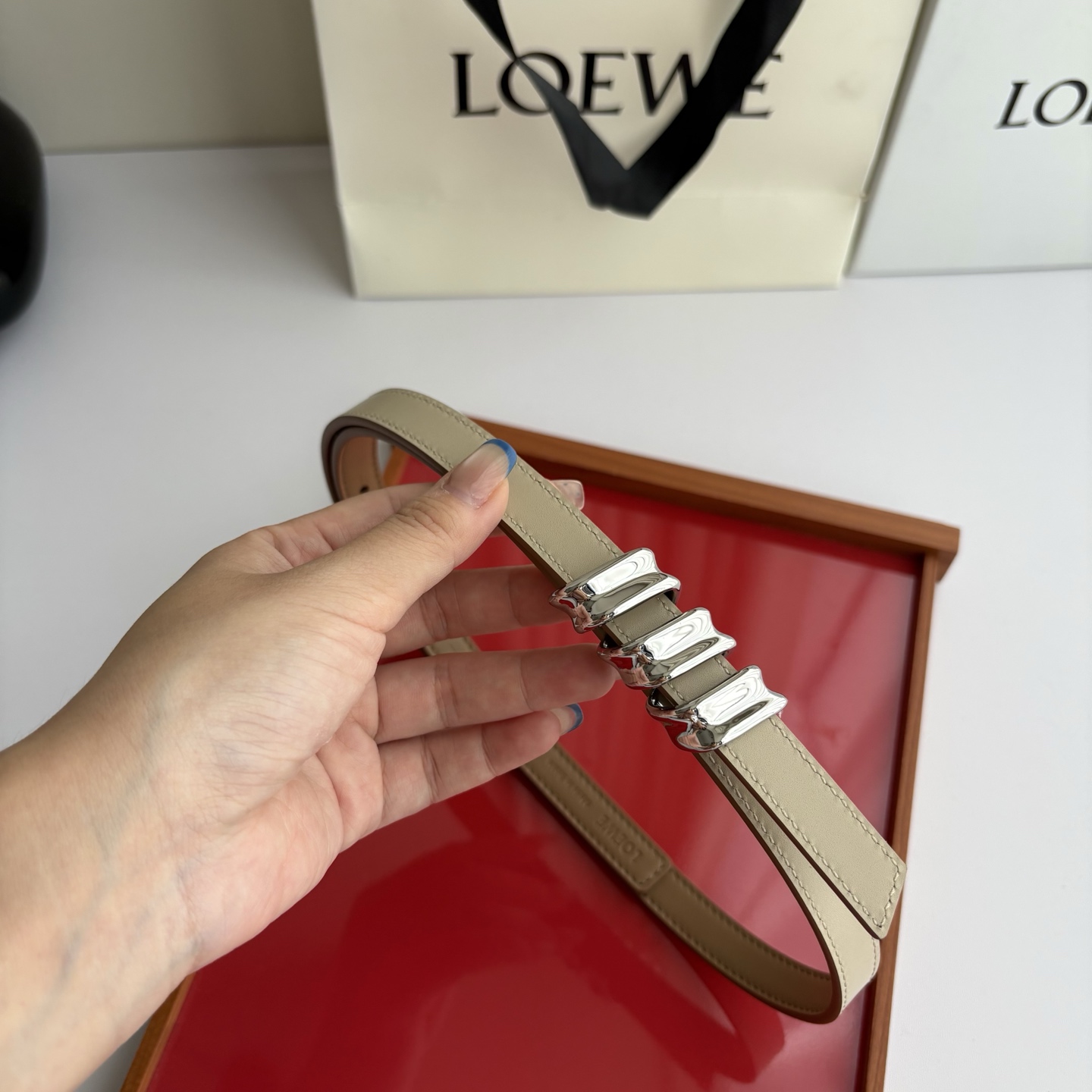 Loewe光滑牛皮革Coil双面腰带，饰有灵感源自品牌典藏的盘绕配件。Anchor腰带扣，宽1.5cm，五孔调节。摩卡色