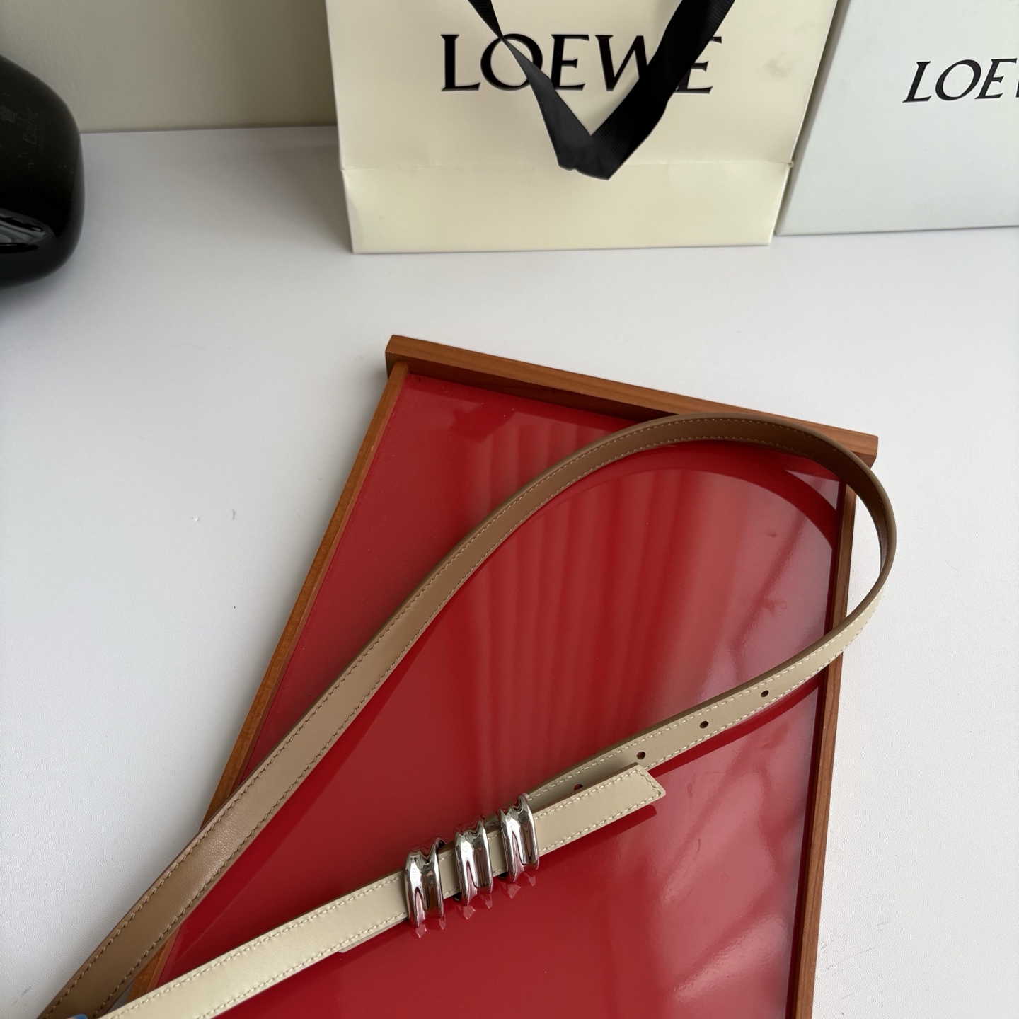 Loewe光滑牛皮革Coil双面腰带，饰有灵感源自品牌典藏的盘绕配件。Anchor腰带扣，宽1.5cm，五孔调节。摩卡色
