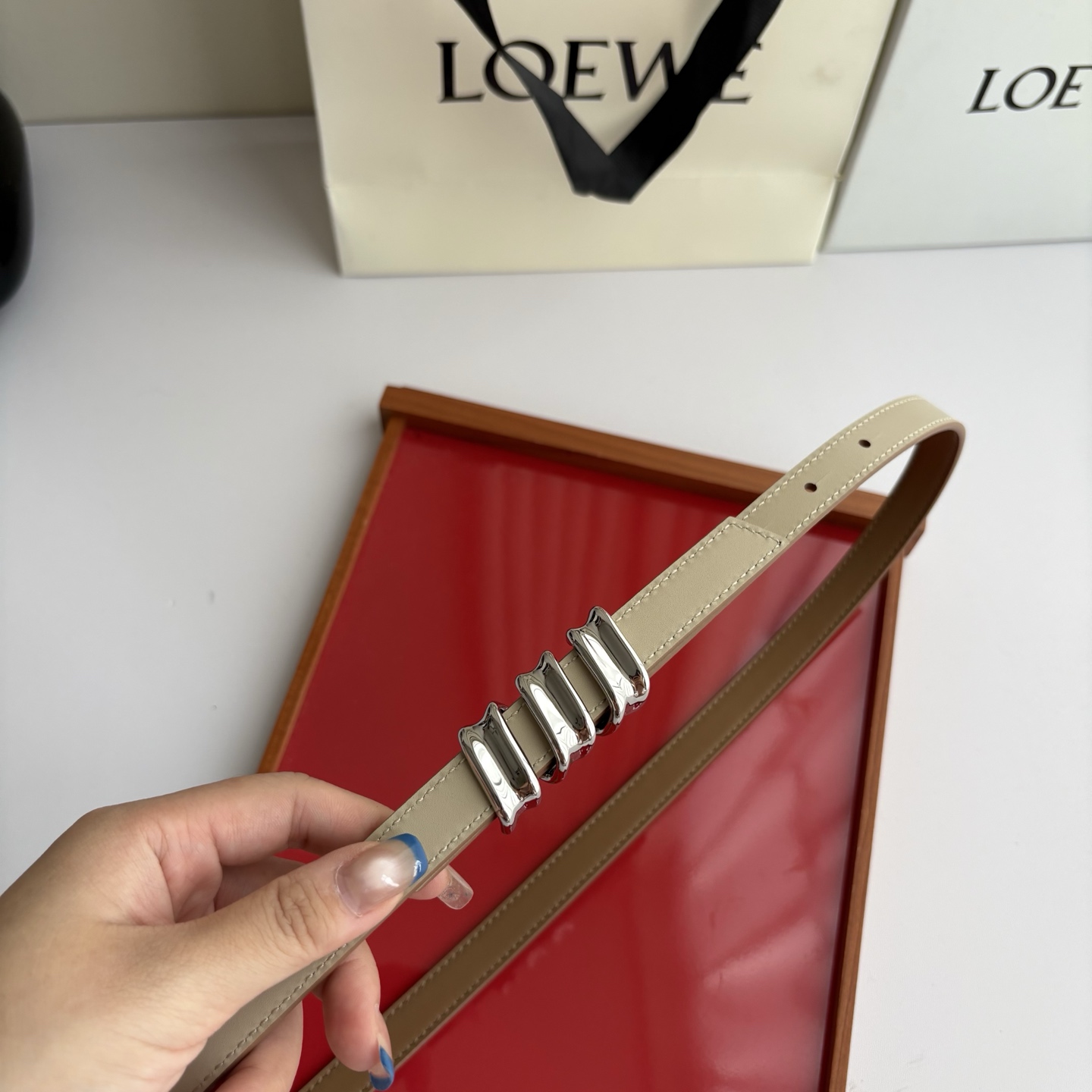 Loewe光滑牛皮革Coil双面腰带，饰有灵感源自品牌典藏的盘绕配件。Anchor腰带扣，宽1.5cm，五孔调节。摩卡色