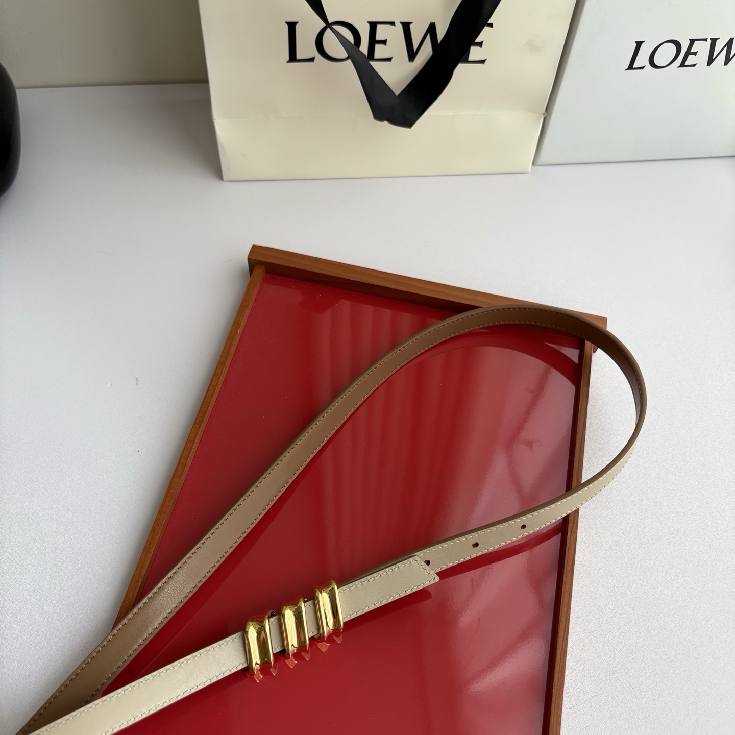 Loewe光滑牛皮革Coil双面腰带，饰有灵感源自品牌典藏的盘绕配件。Anchor腰带扣，宽1.5cm，五孔调节。摩卡色