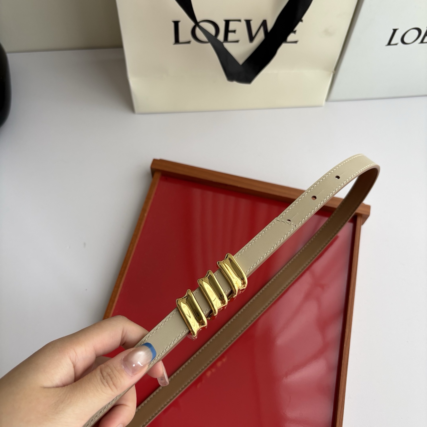 Loewe光滑牛皮革Coil双面腰带，饰有灵感源自品牌典藏的盘绕配件。Anchor腰带扣，宽1.5cm，五孔调节。摩卡色