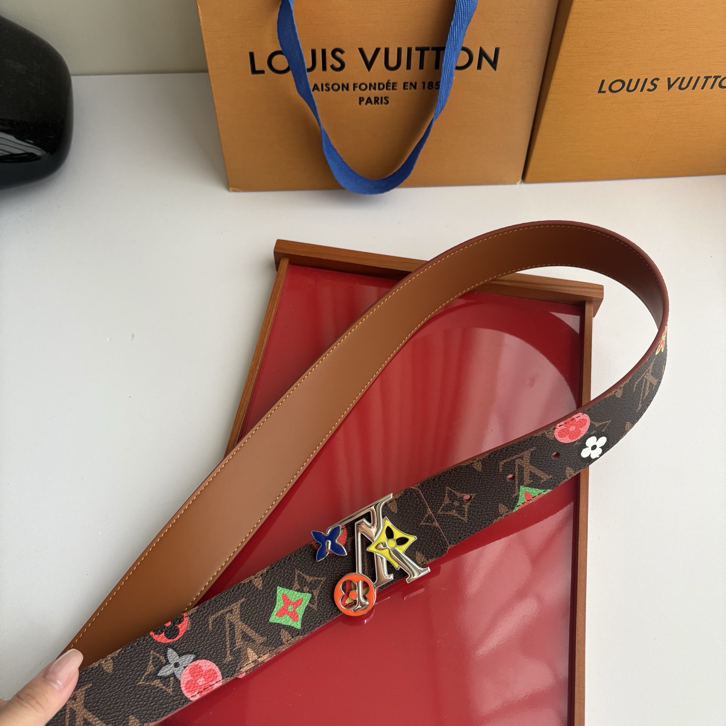 Lv当季新款，经典老花底色，叠加粉、绿、红彩色四花涂鸦印花，两面切换佩戴。正面彩色限定印花帆布；反面棕褐色光滑牛皮。宽4