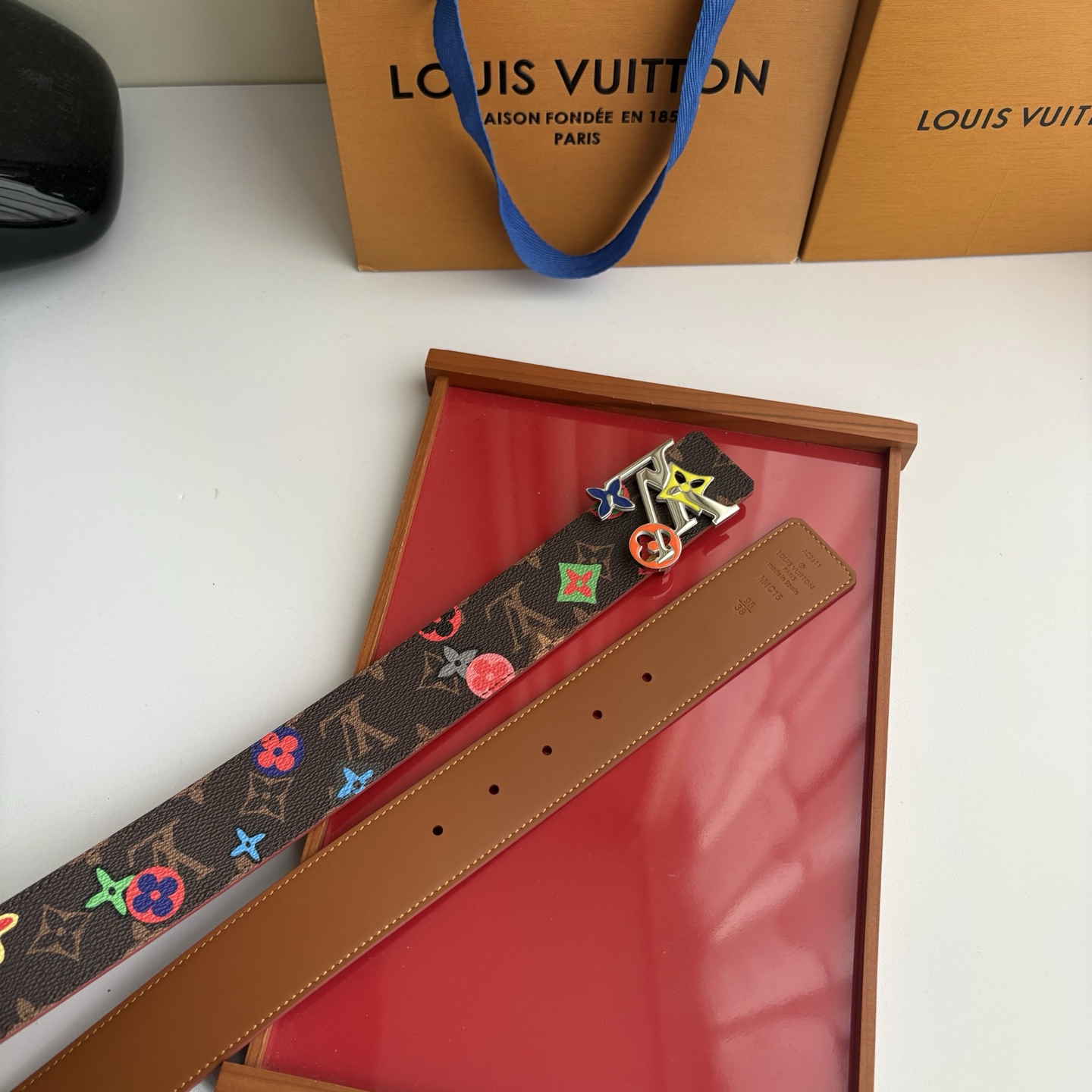 Lv当季新款，经典老花底色，叠加粉、绿、红彩色四花涂鸦印花，两面切换佩戴。正面彩色限定印花帆布；反面棕褐色光滑牛皮。宽4